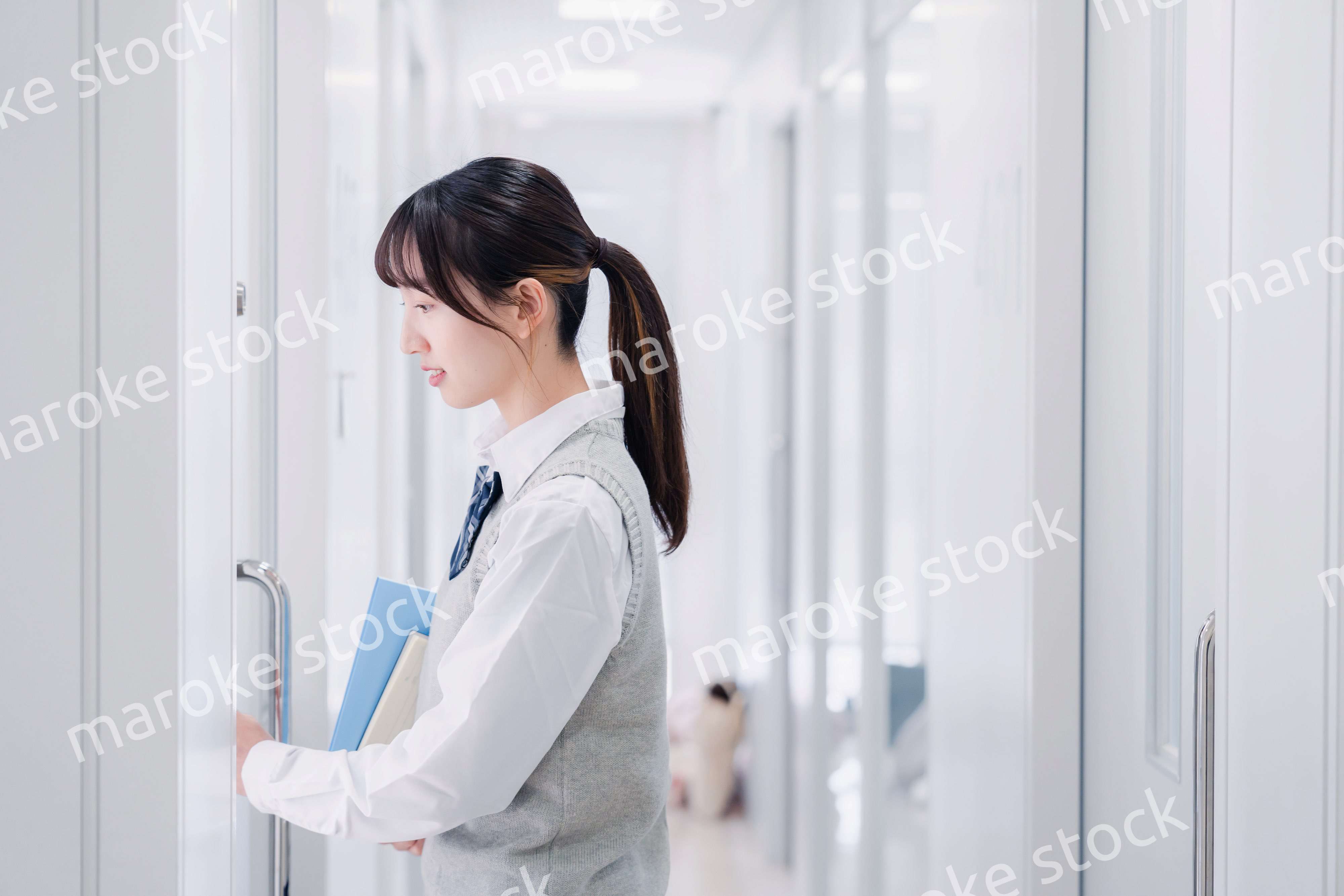 教材を持って校内を歩く女子高生