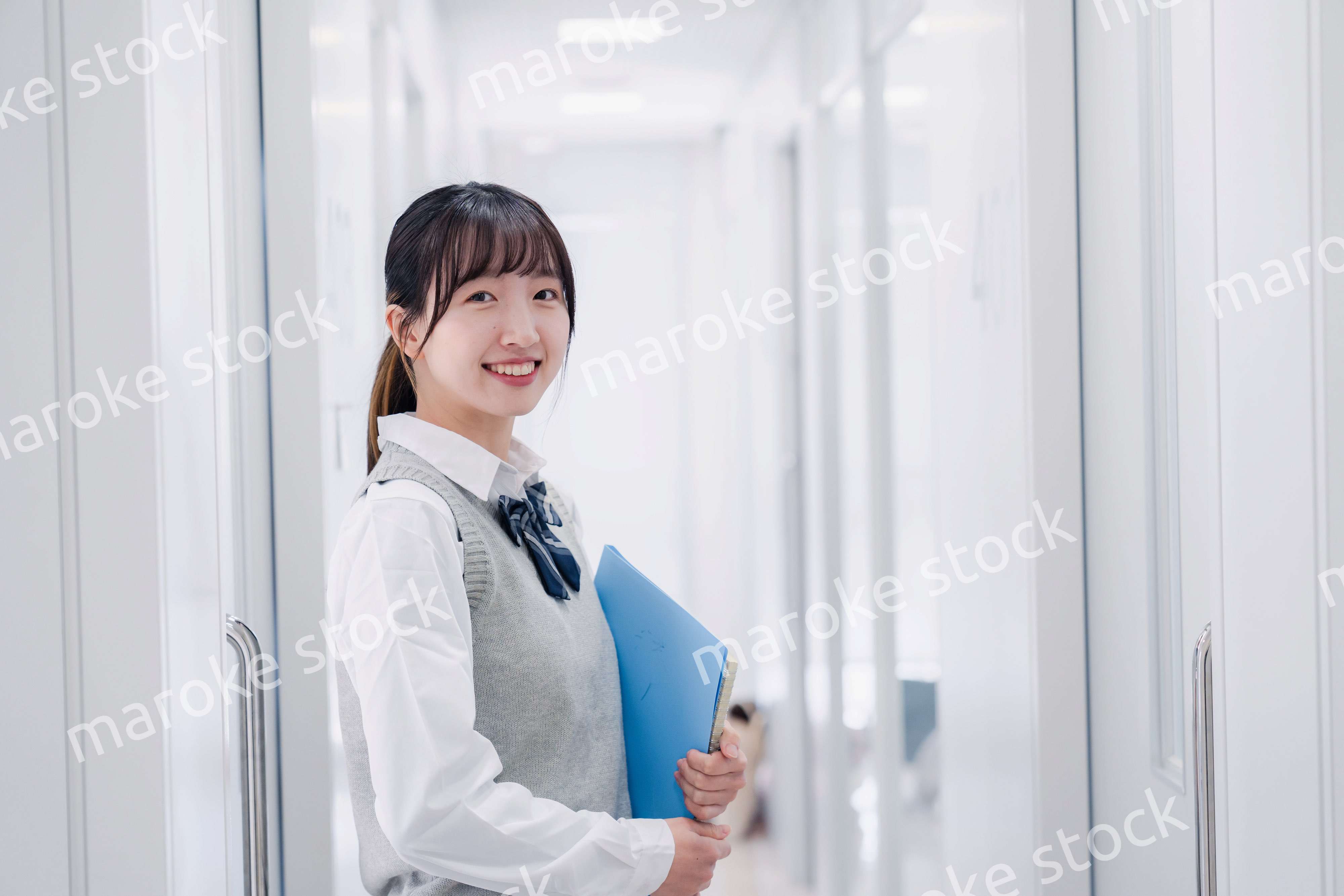 教材を持って校内を歩く女子高生