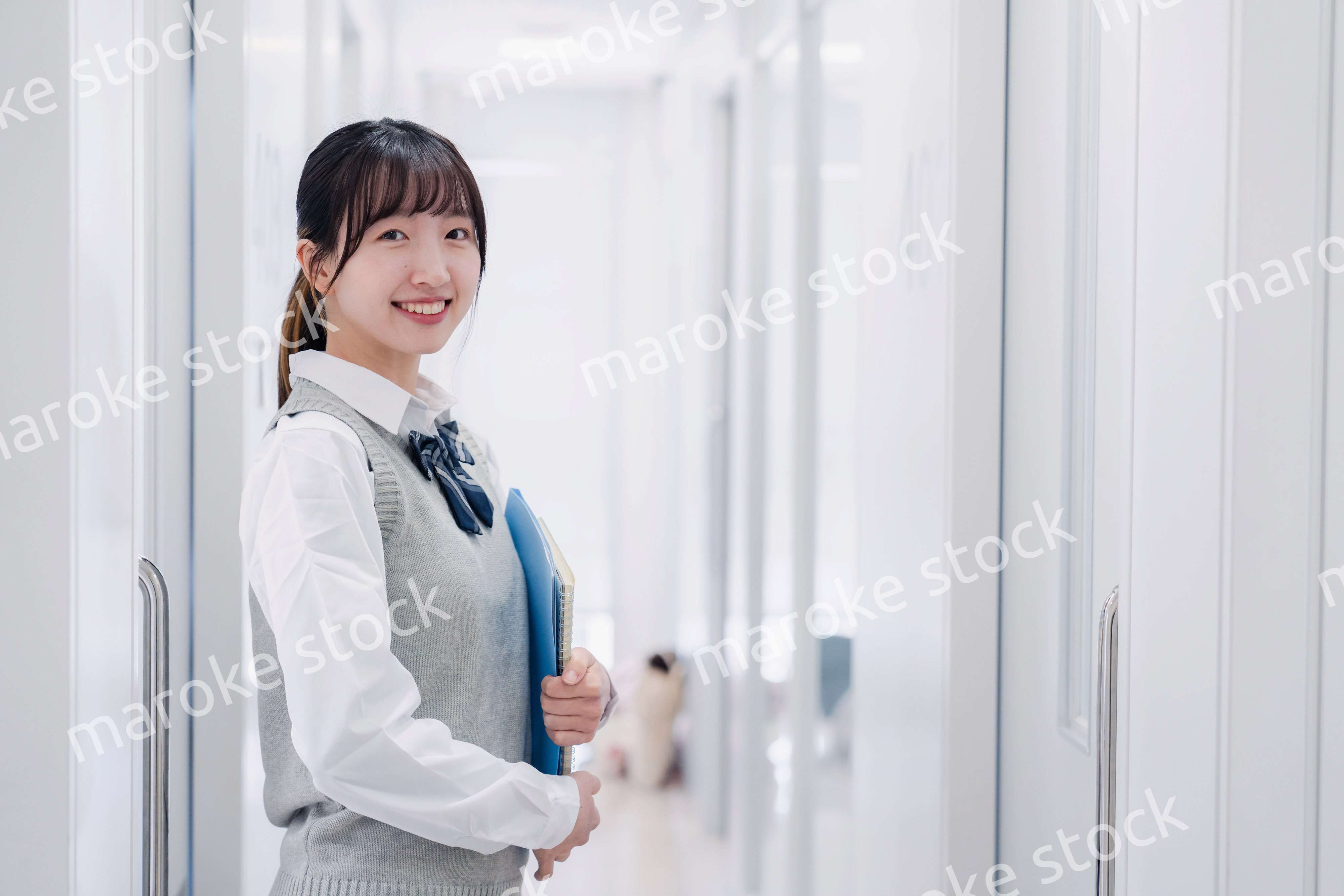 教材を持って校内を歩く女子高生