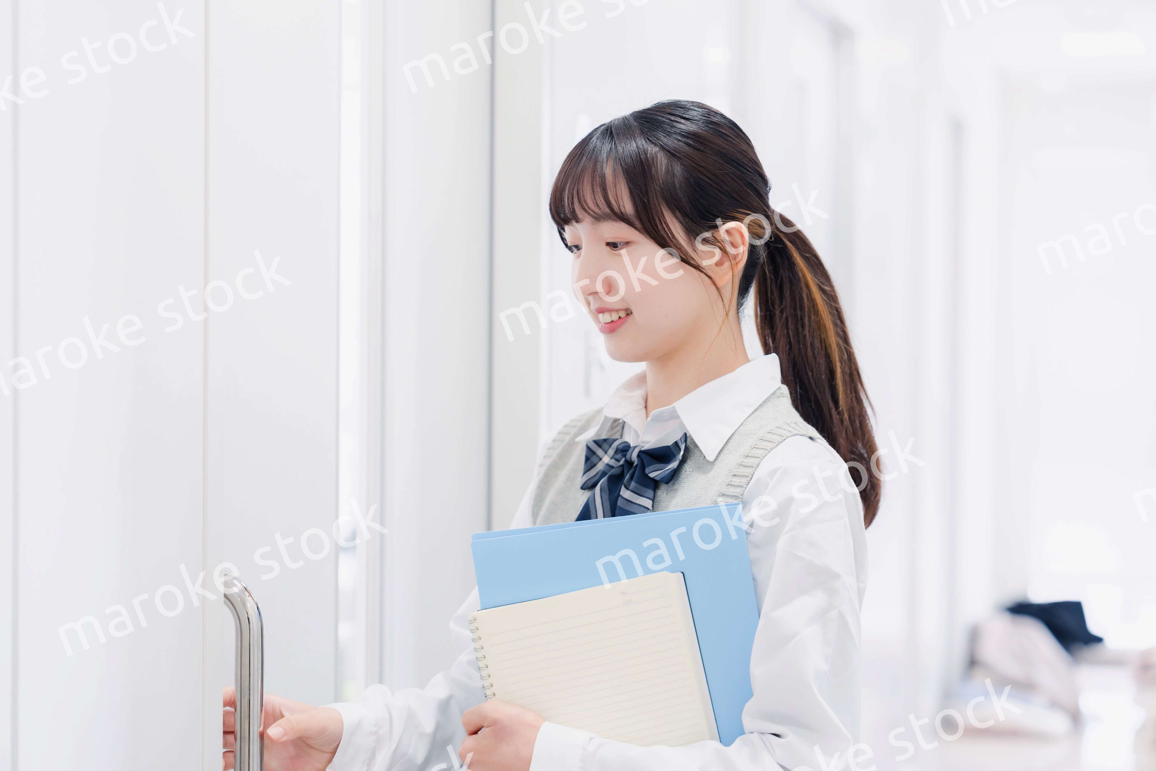 教材を持って校内を歩く女子高生