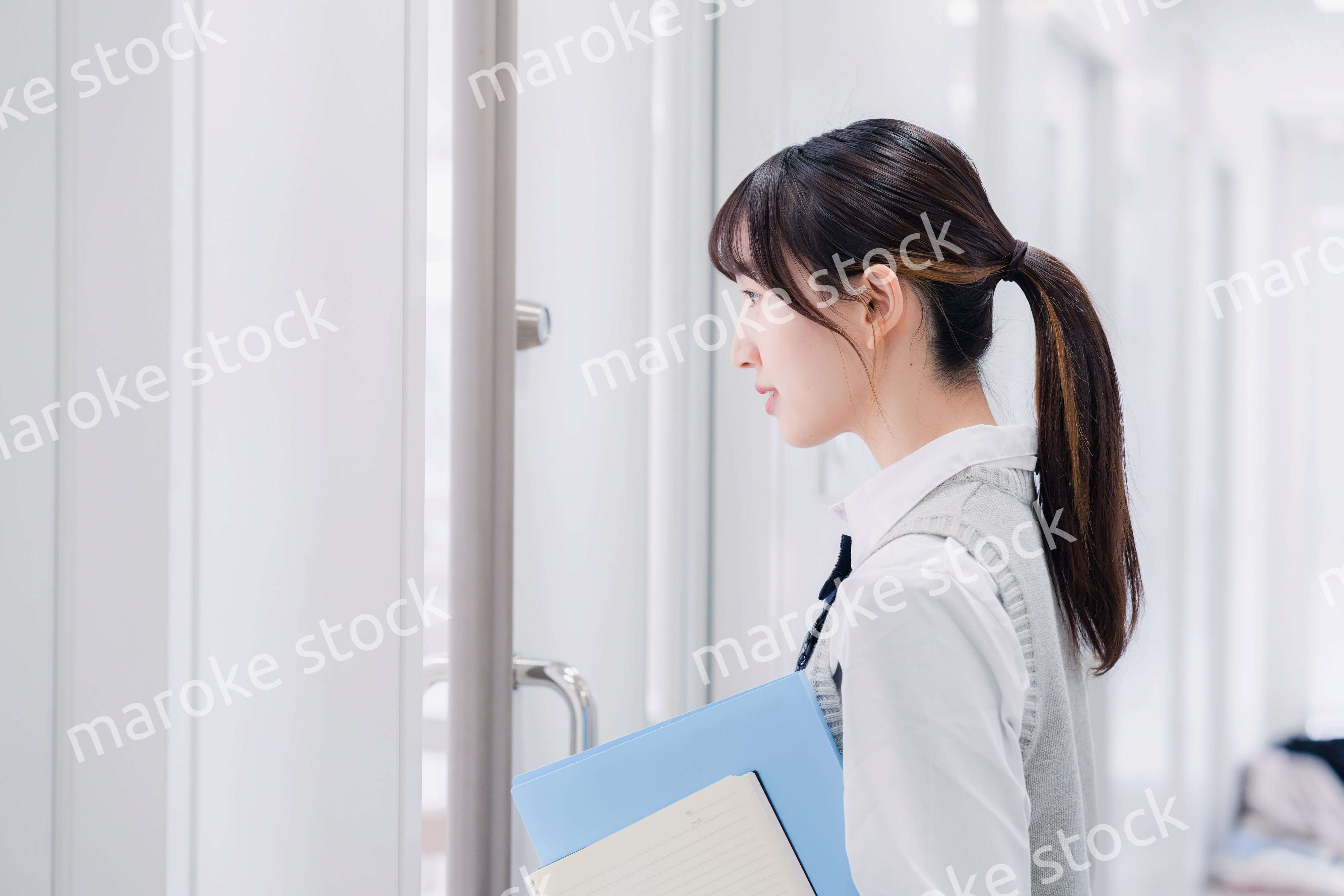 教材を持って校内を歩く女子高生