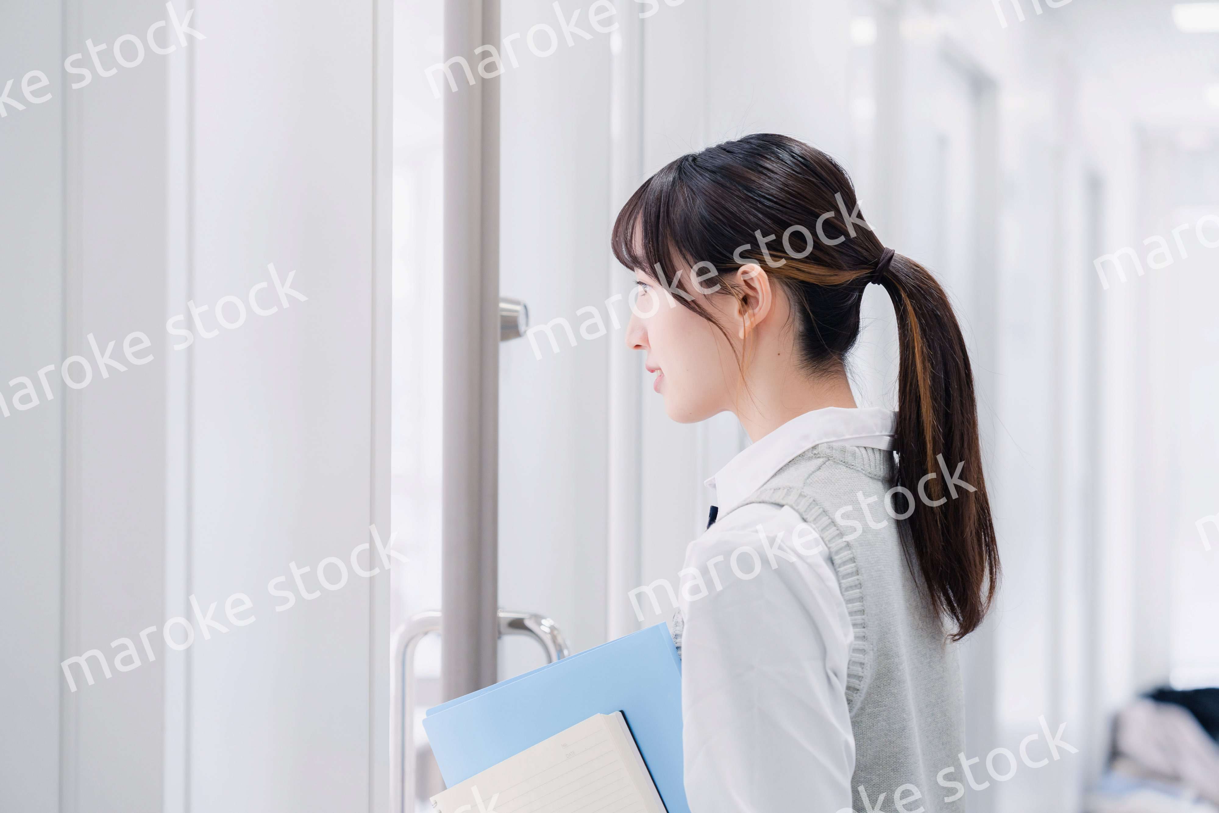 教材を持って校内を歩く女子高生