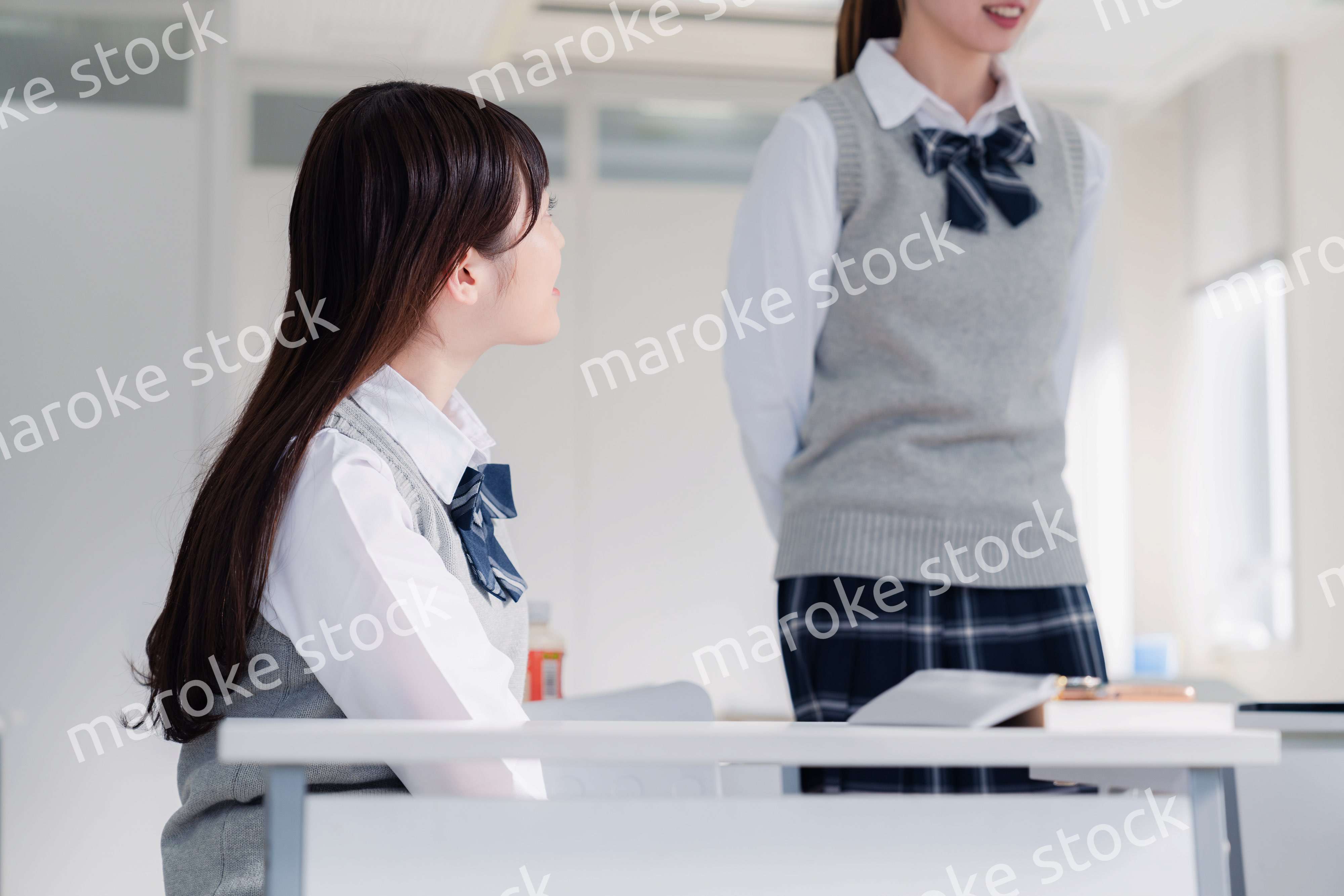 教室で休み時間に話す女子高生