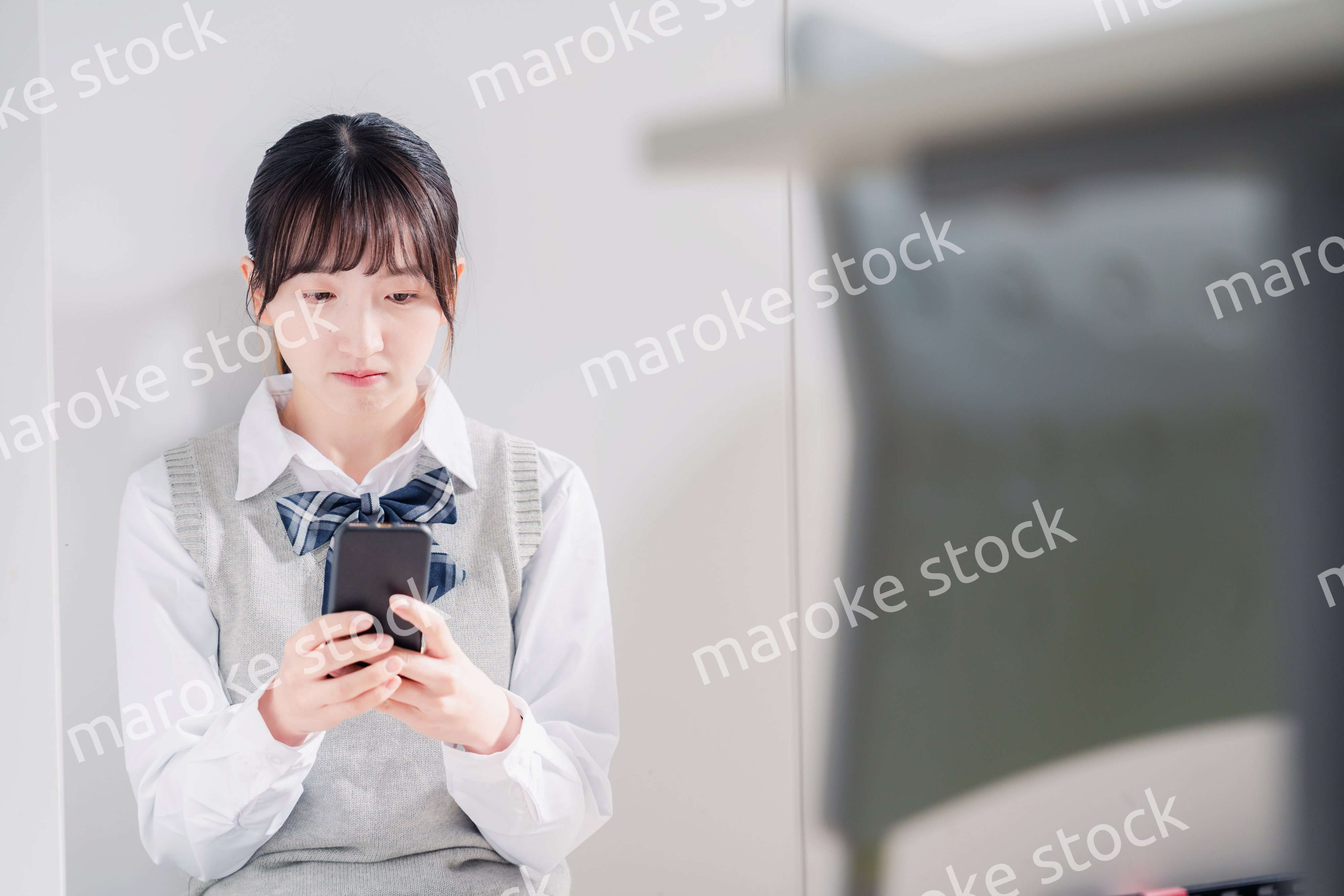 スマホを見ながら落ち込む女子高生