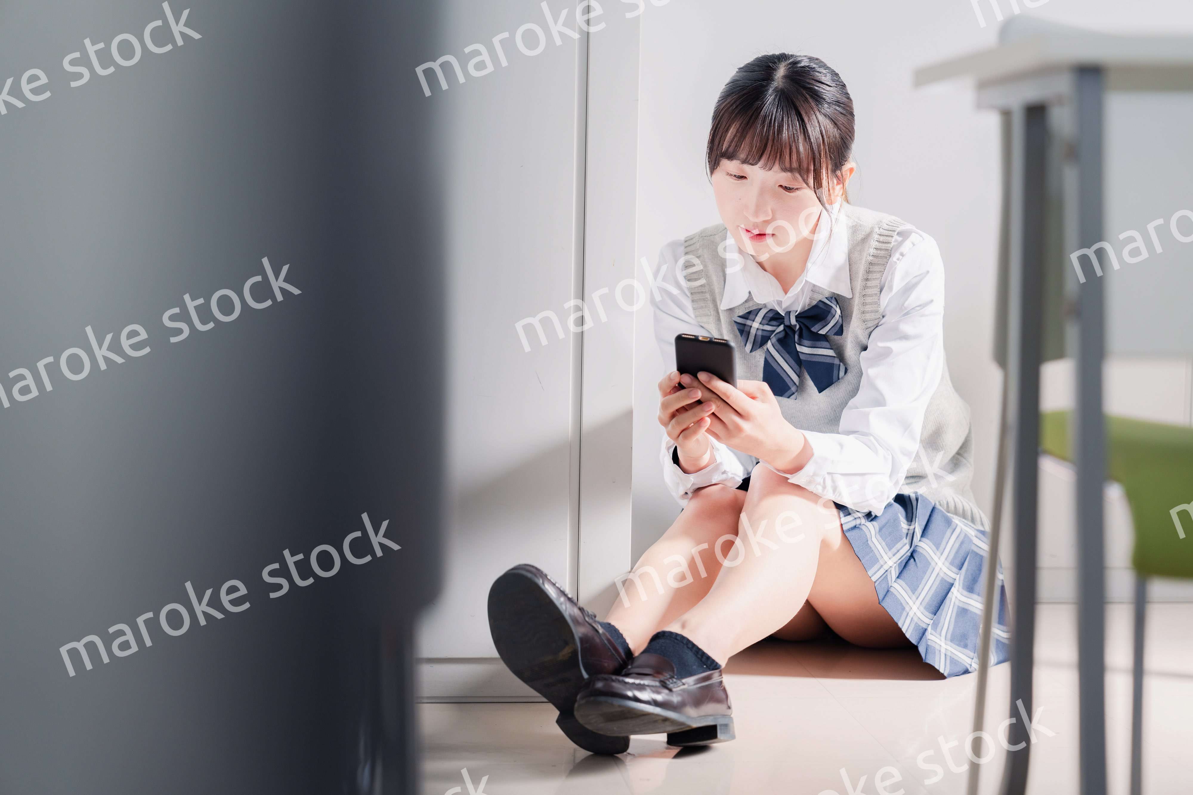 スマホを見ながら落ち込む女子高生
