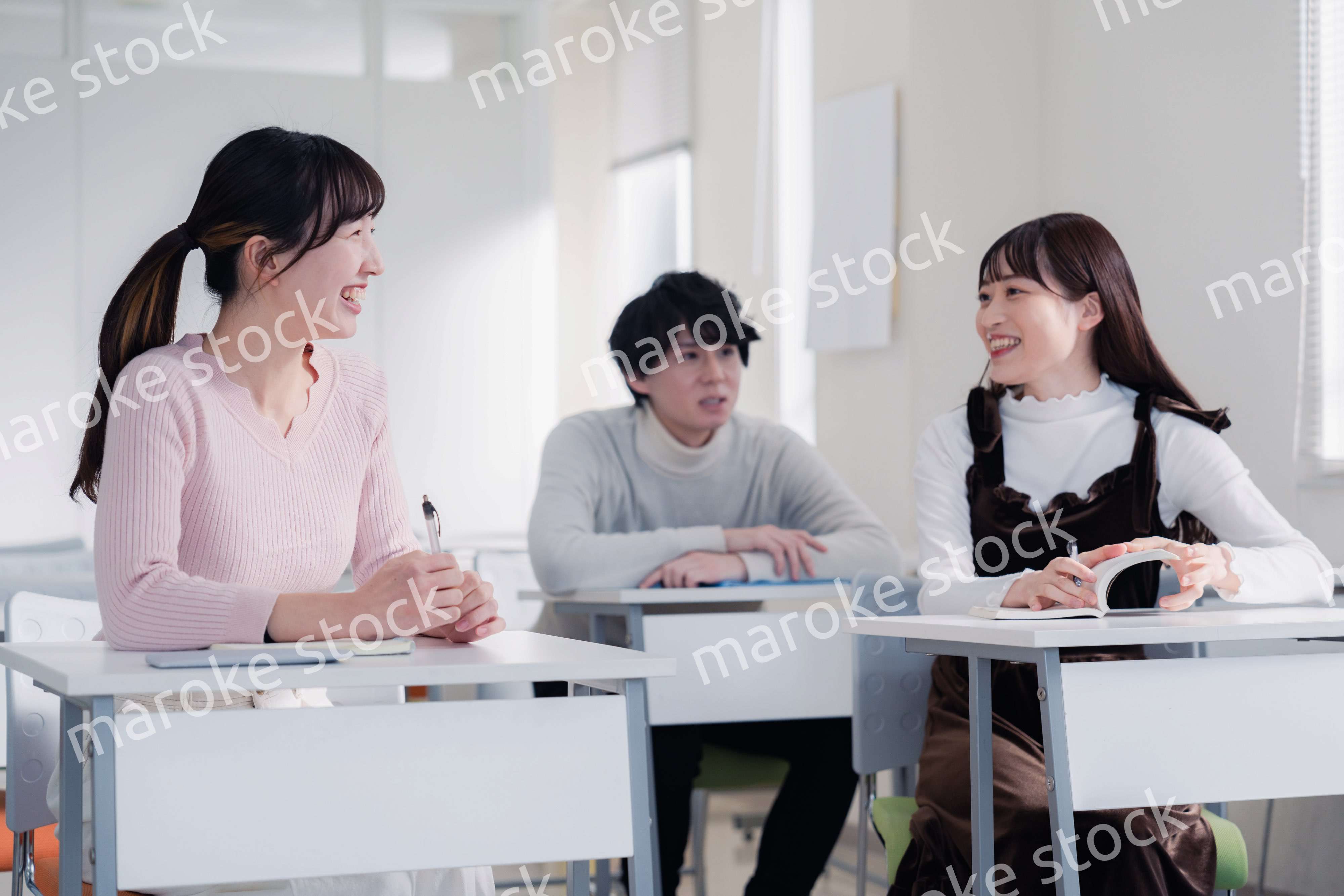 キャンパスで仲良く話をする大学生