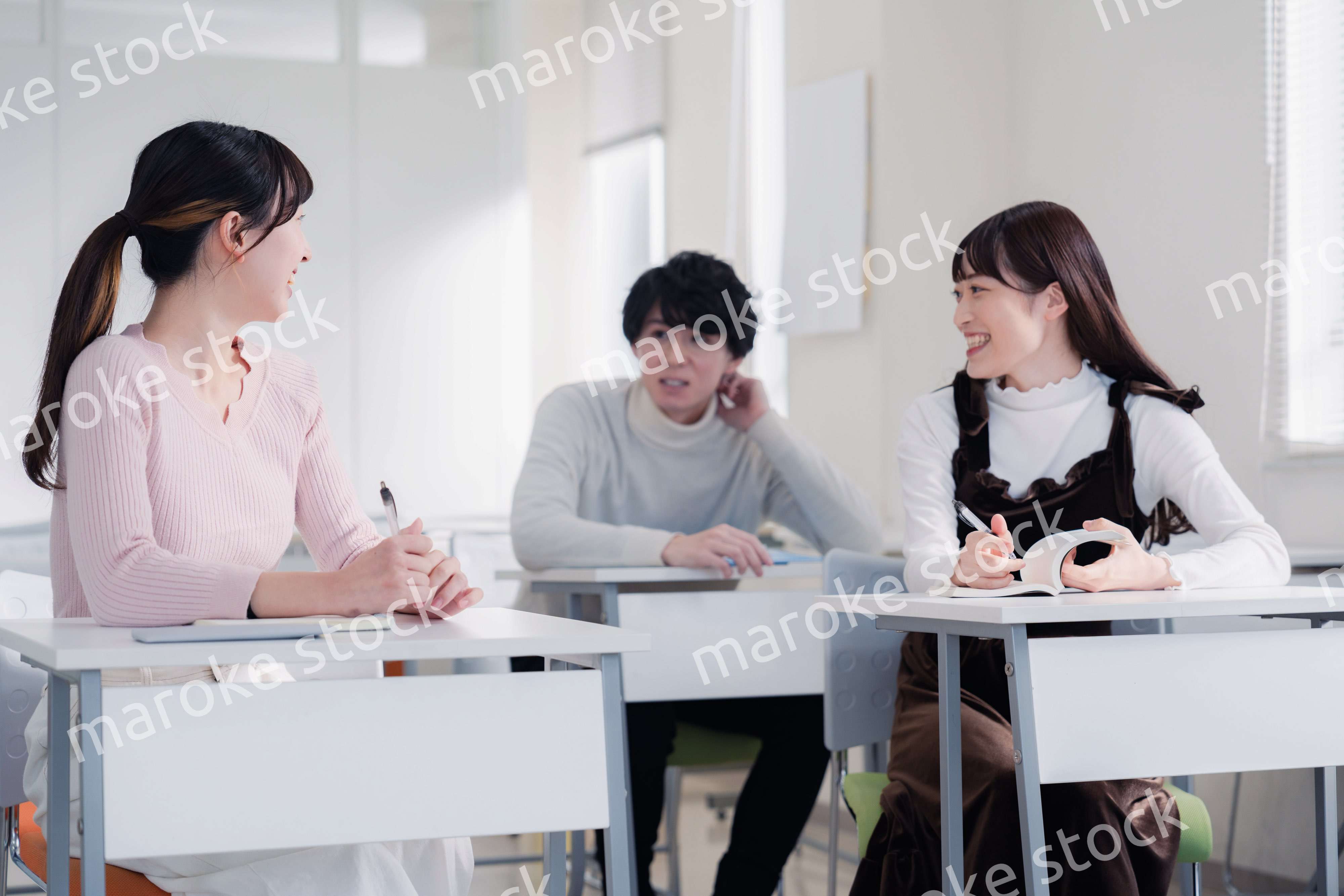 キャンパスで仲良く話をする大学生