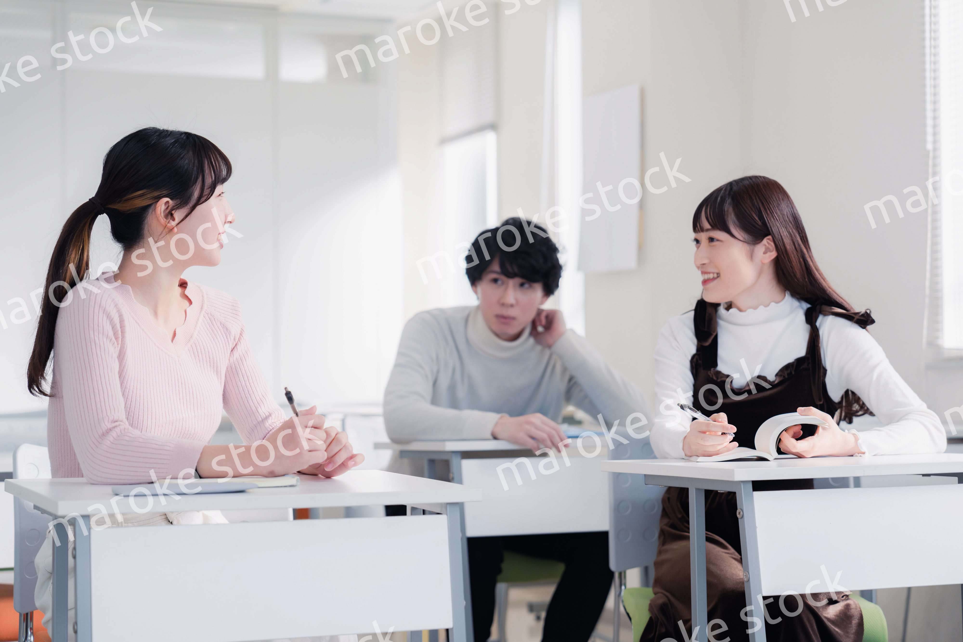 キャンパスで仲良く話をする大学生