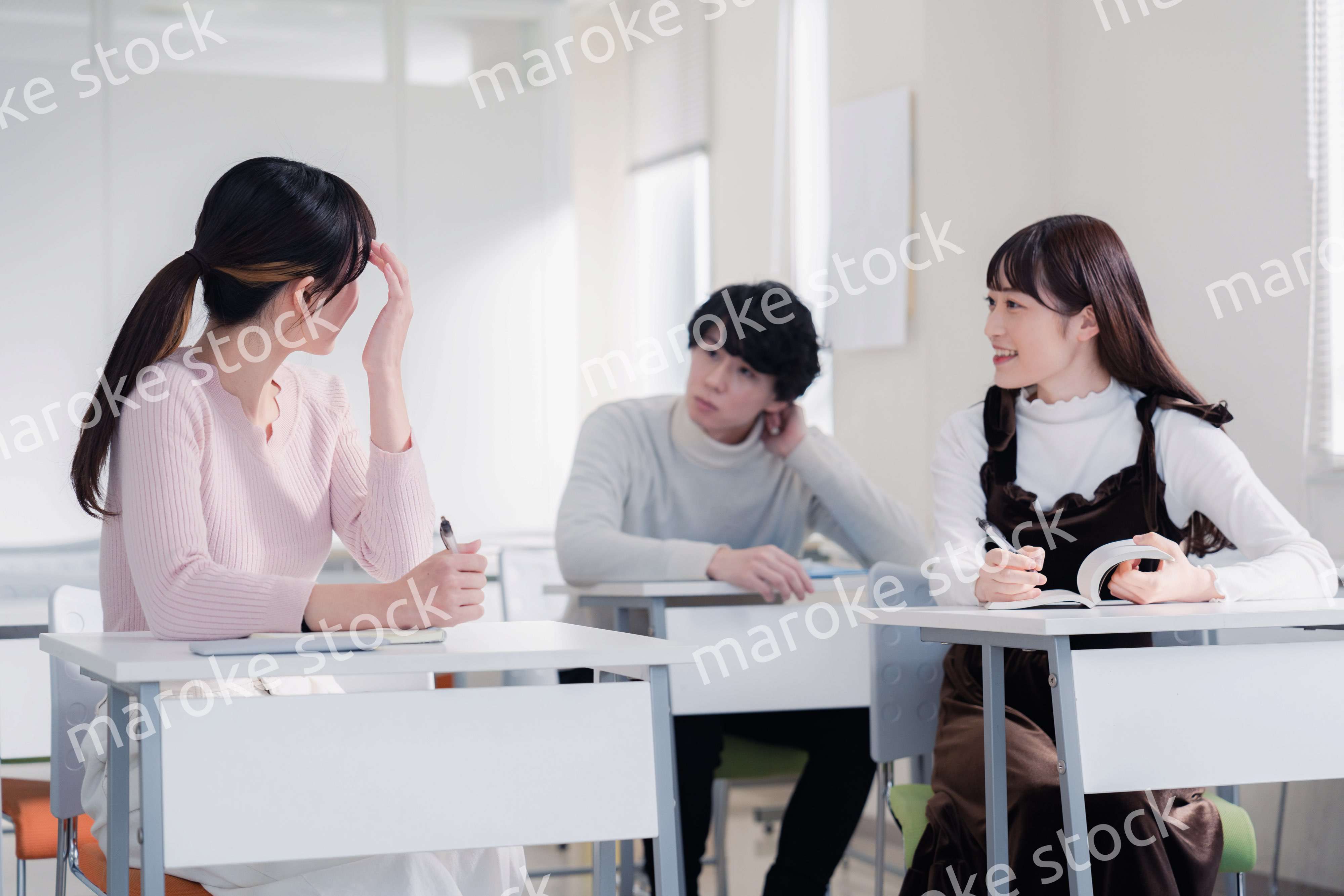 キャンパスで仲良く話をする大学生