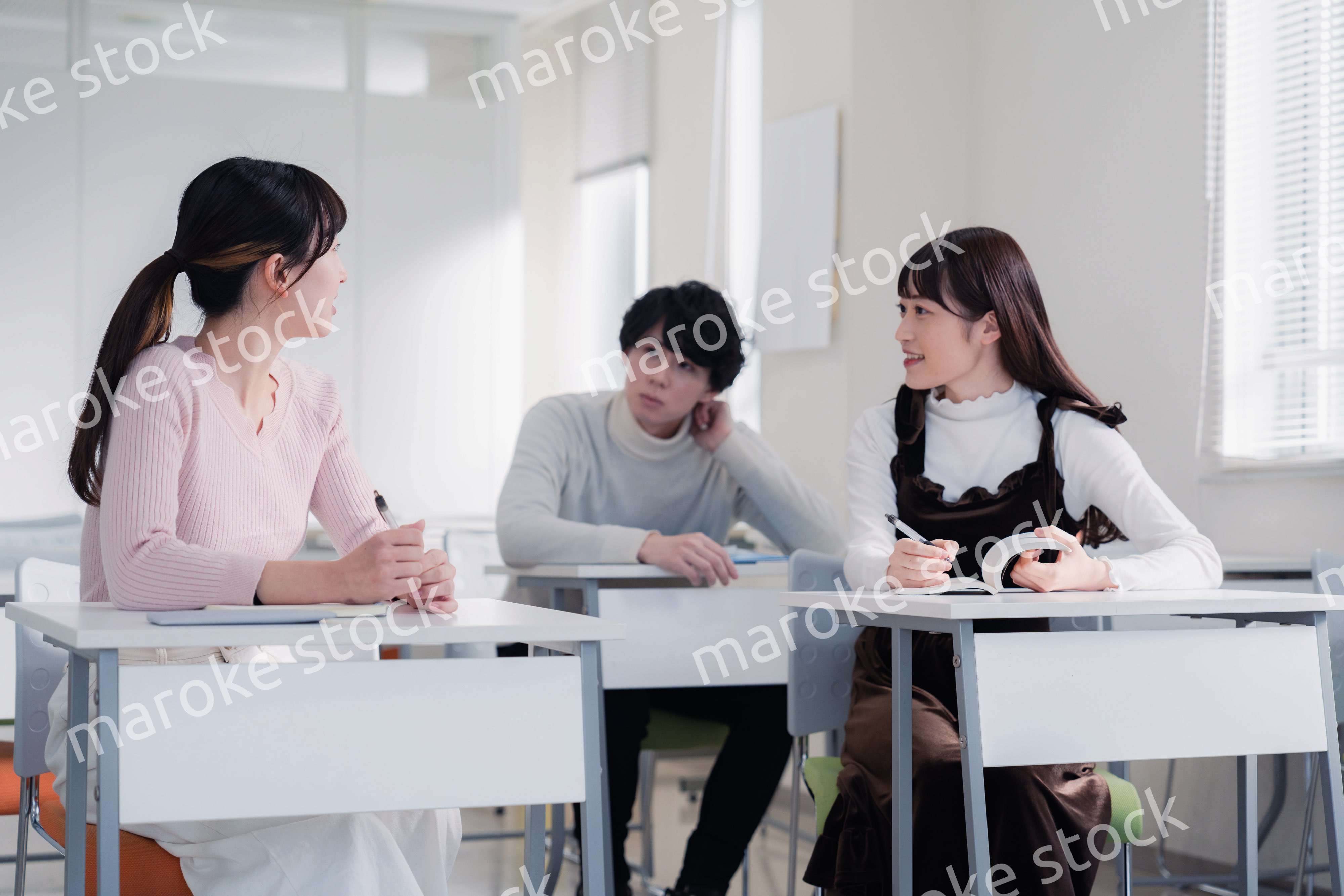 キャンパスで仲良く話をする大学生