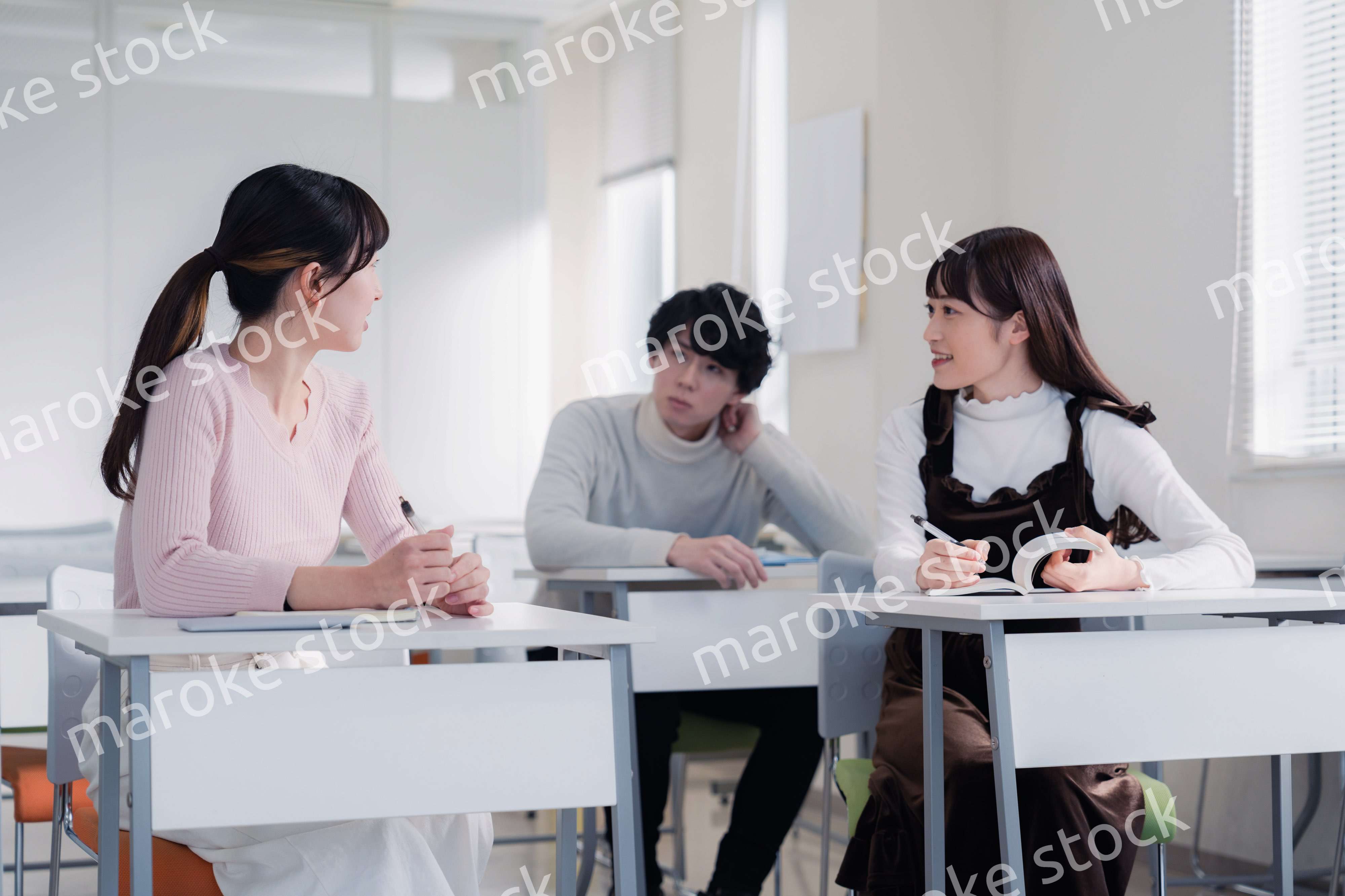 キャンパスで仲良く話をする大学生