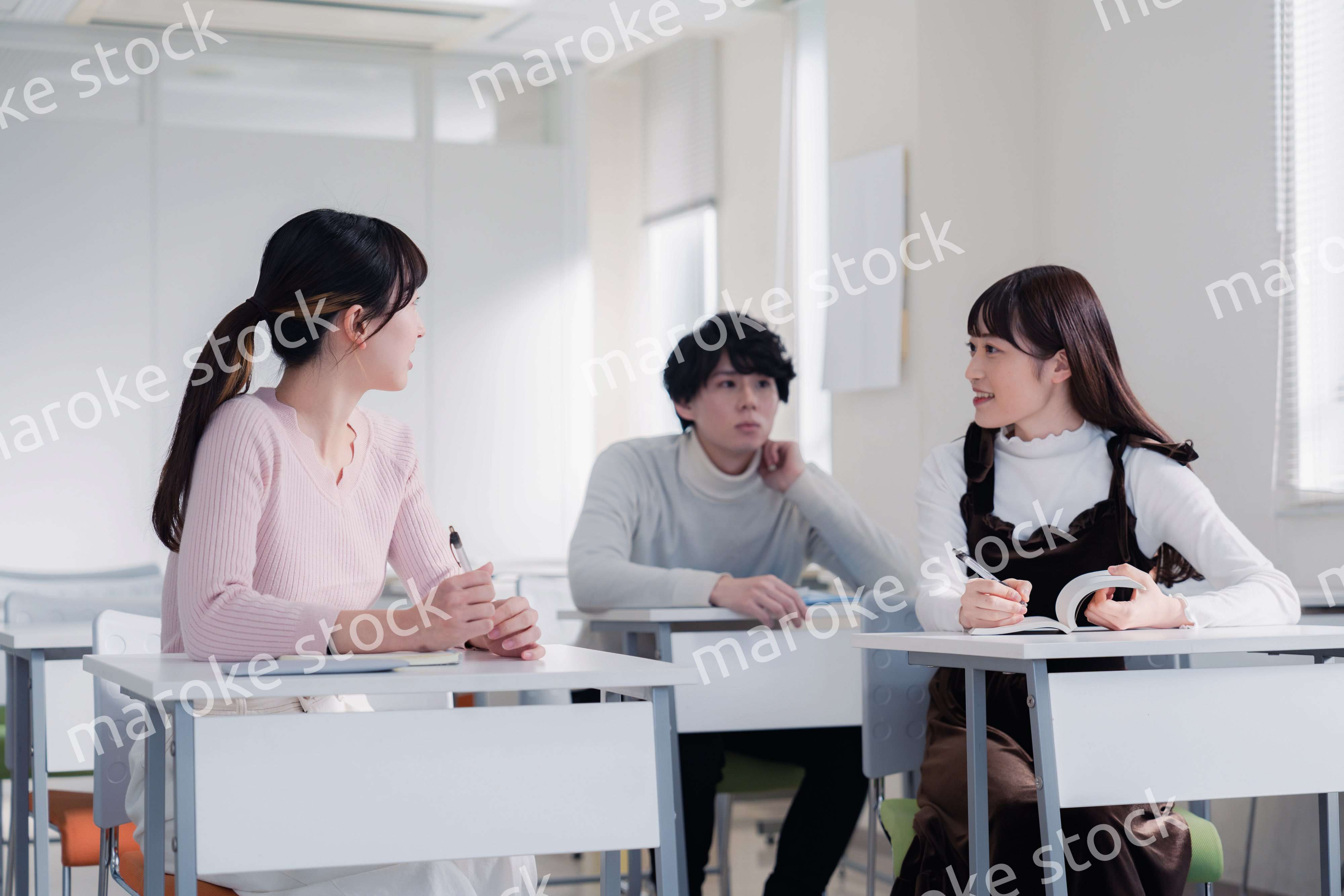 キャンパスで仲良く話をする大学生