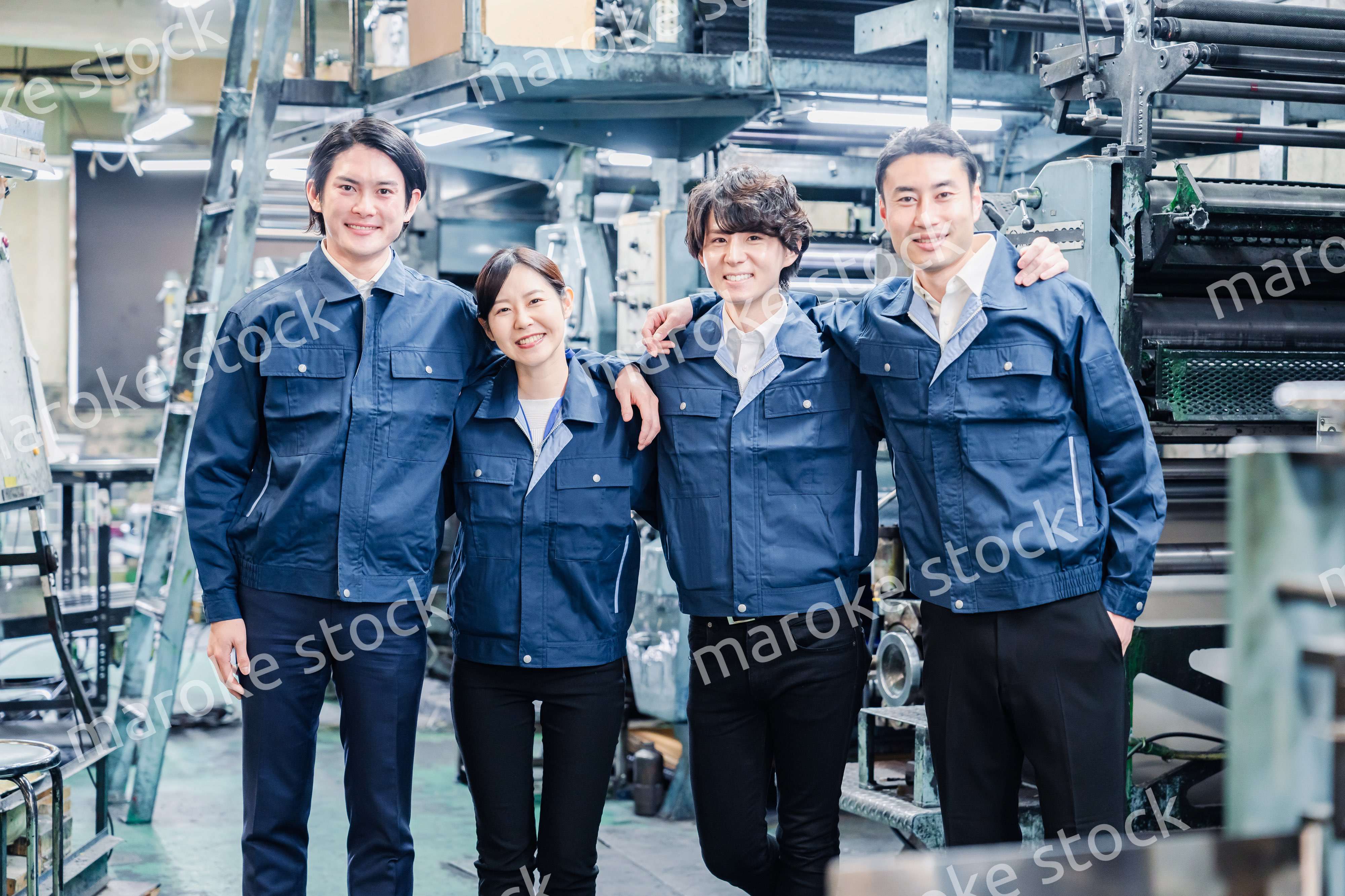仲良く肩を組む工場スタッフ