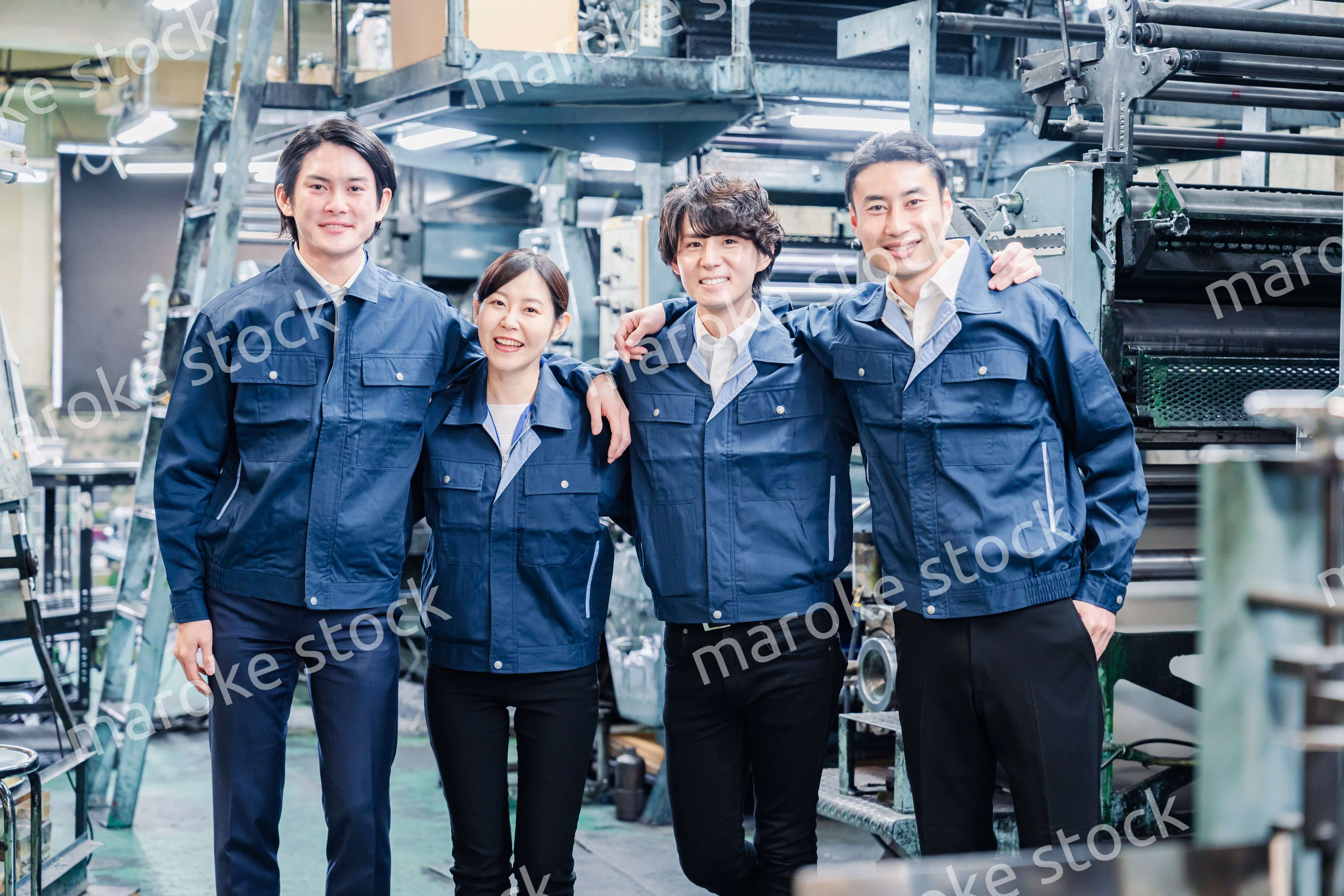 仲良く肩を組む工場スタッフ