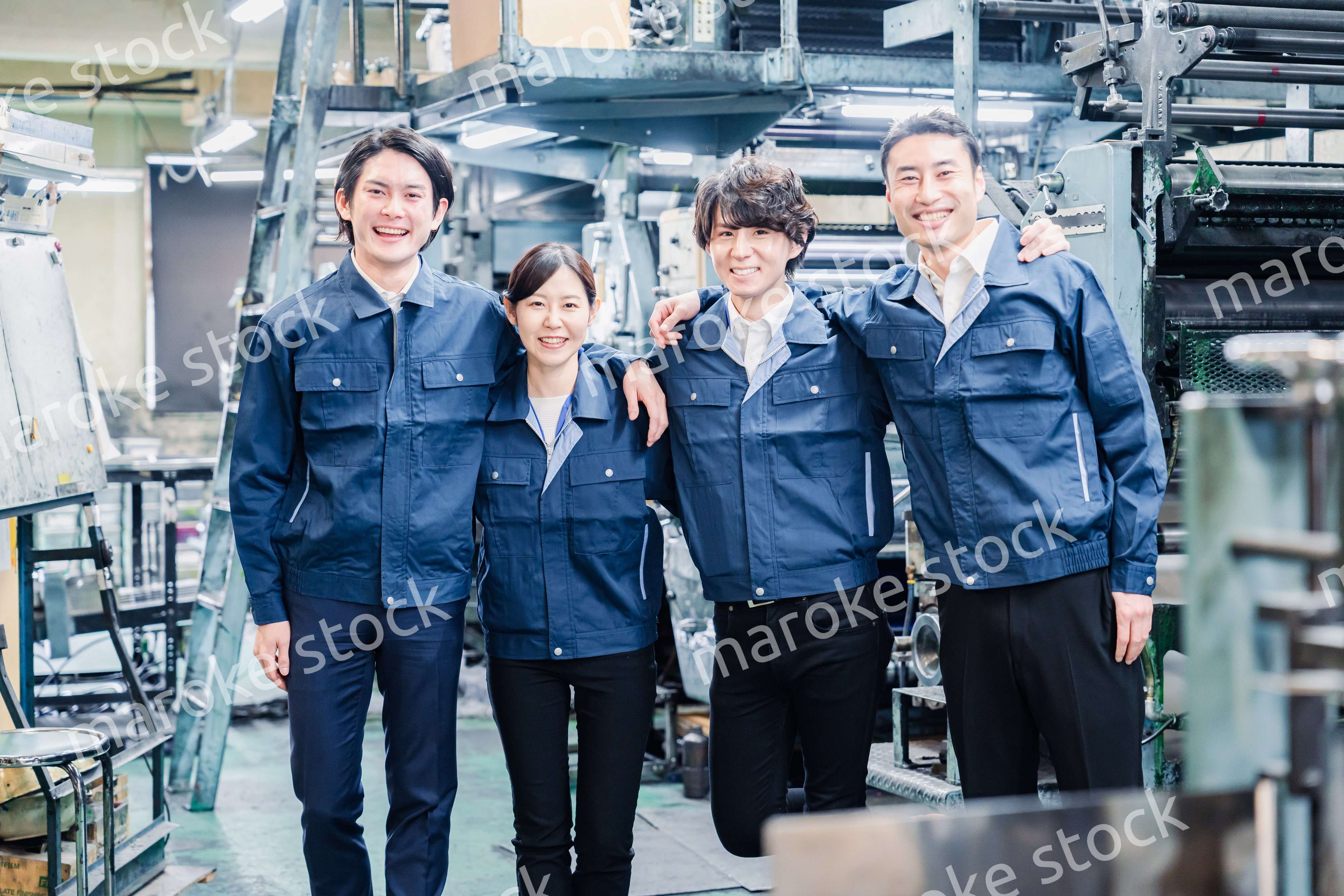 仲良く肩を組む工場スタッフ