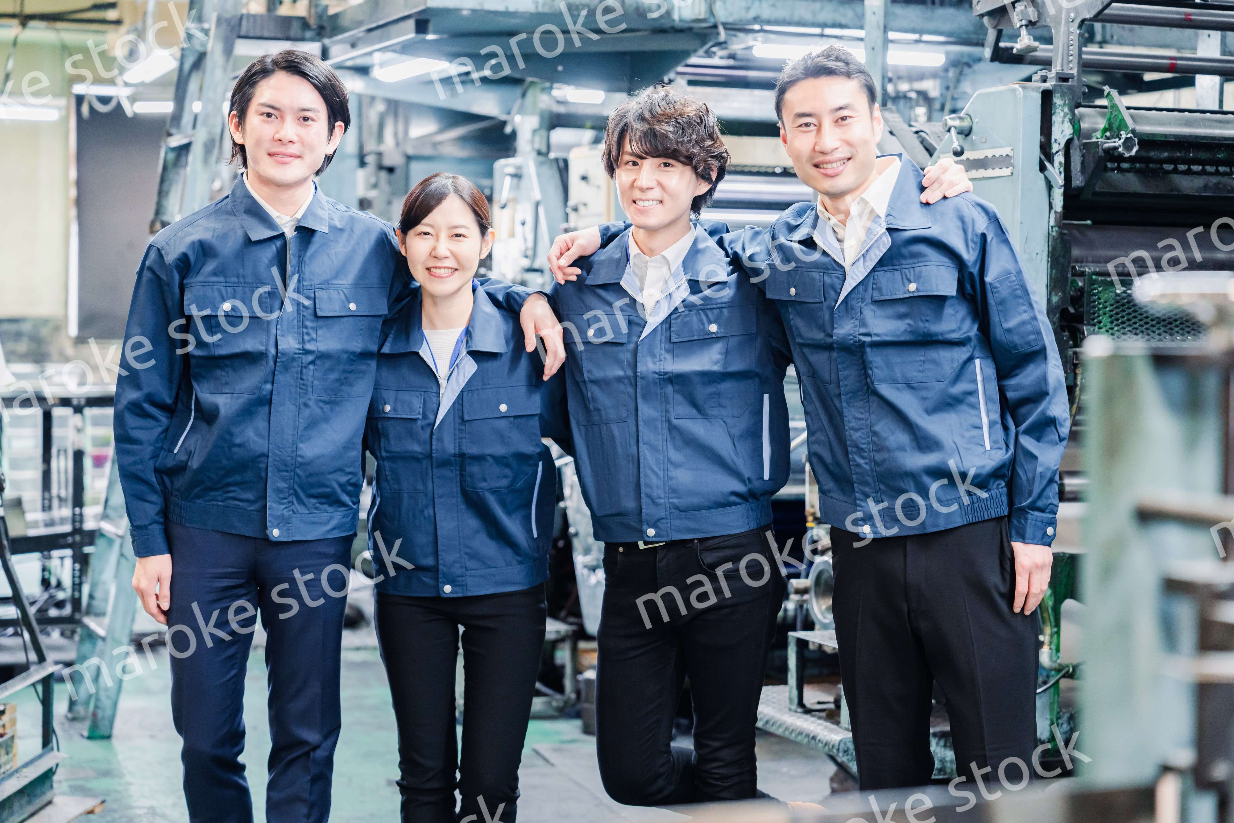 仲良く肩を組む工場スタッフ