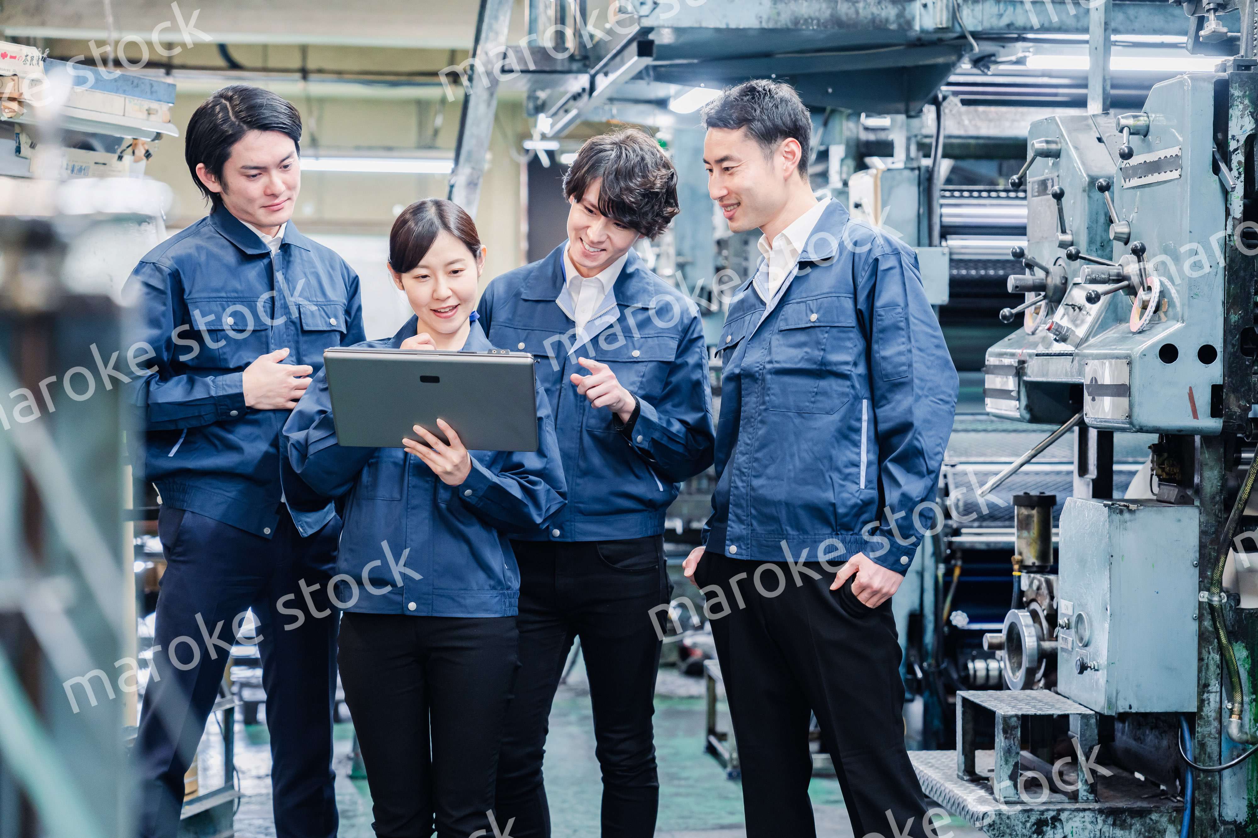 タブレット端末を見ながら会議をする工場スタッフ