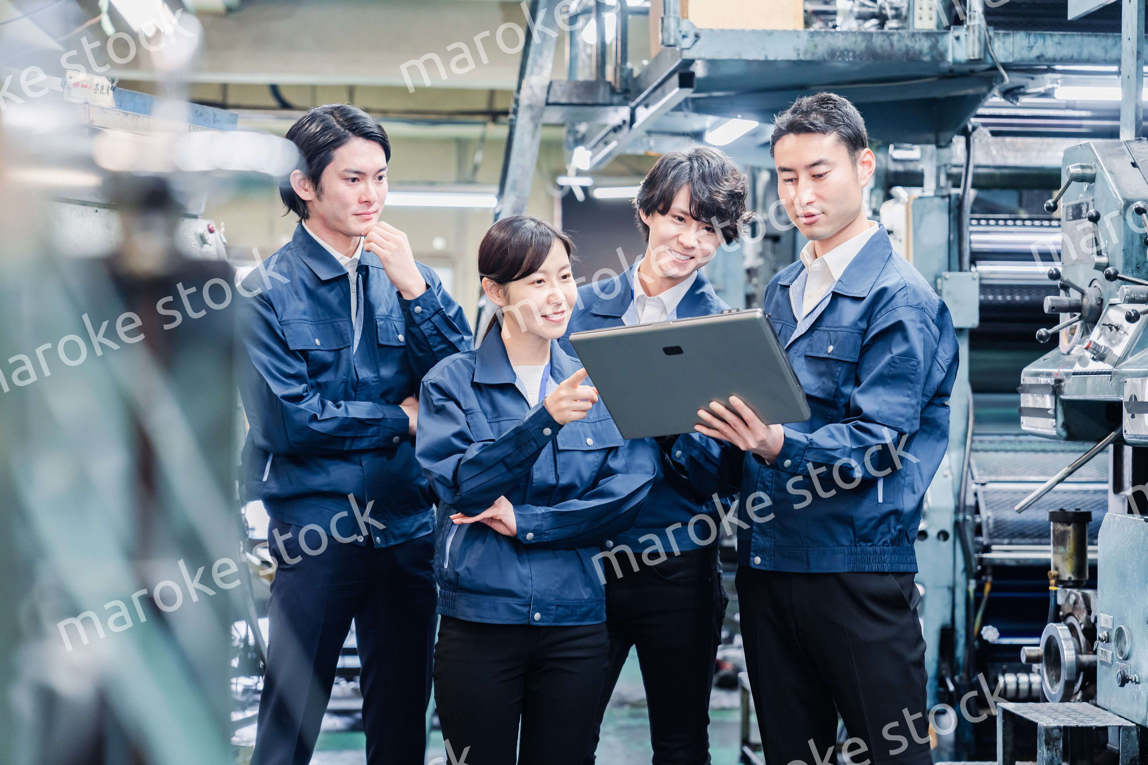 タブレット端末を見ながら会議をする工場スタッフ