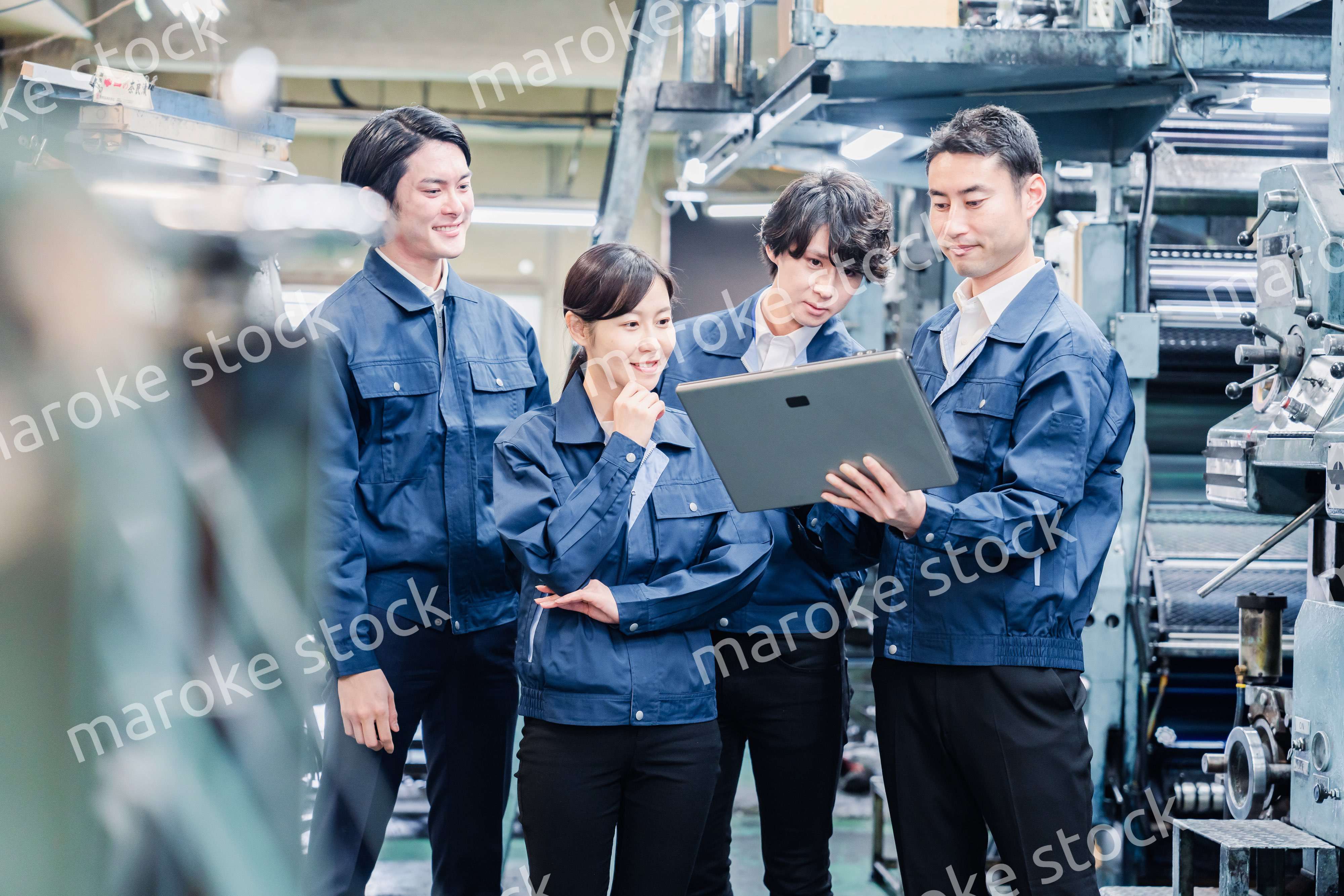 タブレット端末を見ながら会議をする工場スタッフ