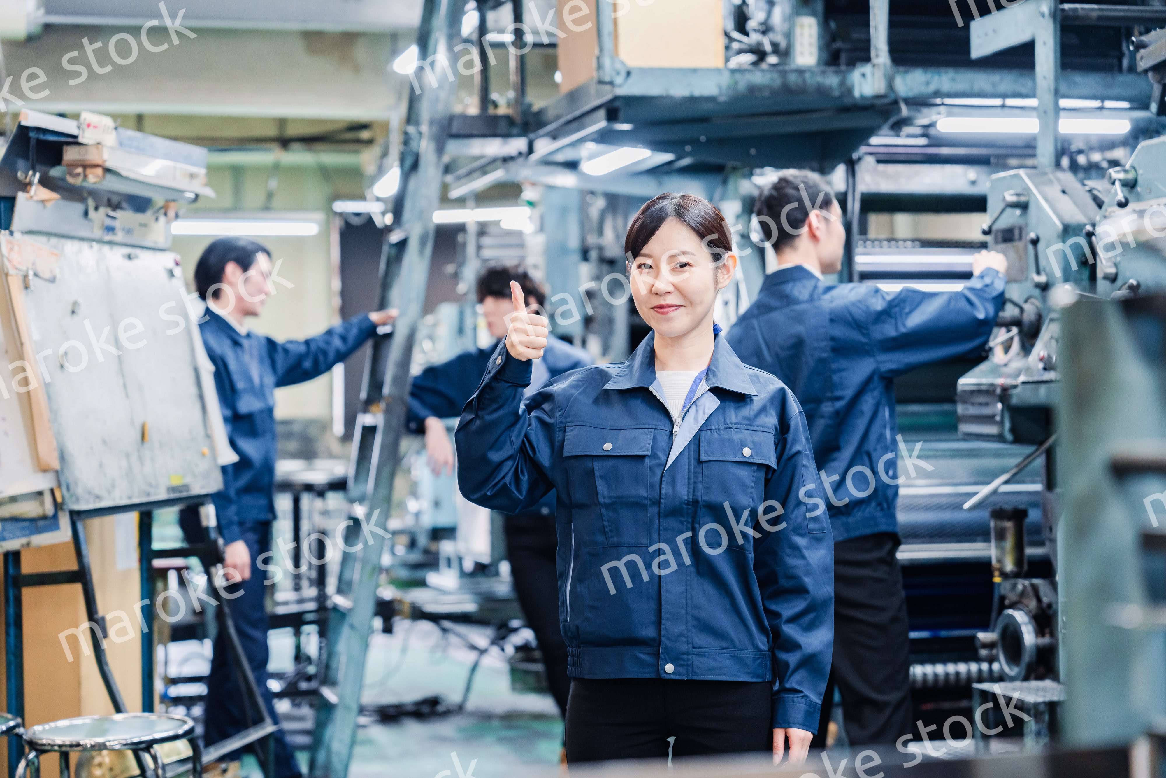 グッドサインをする工場労働者