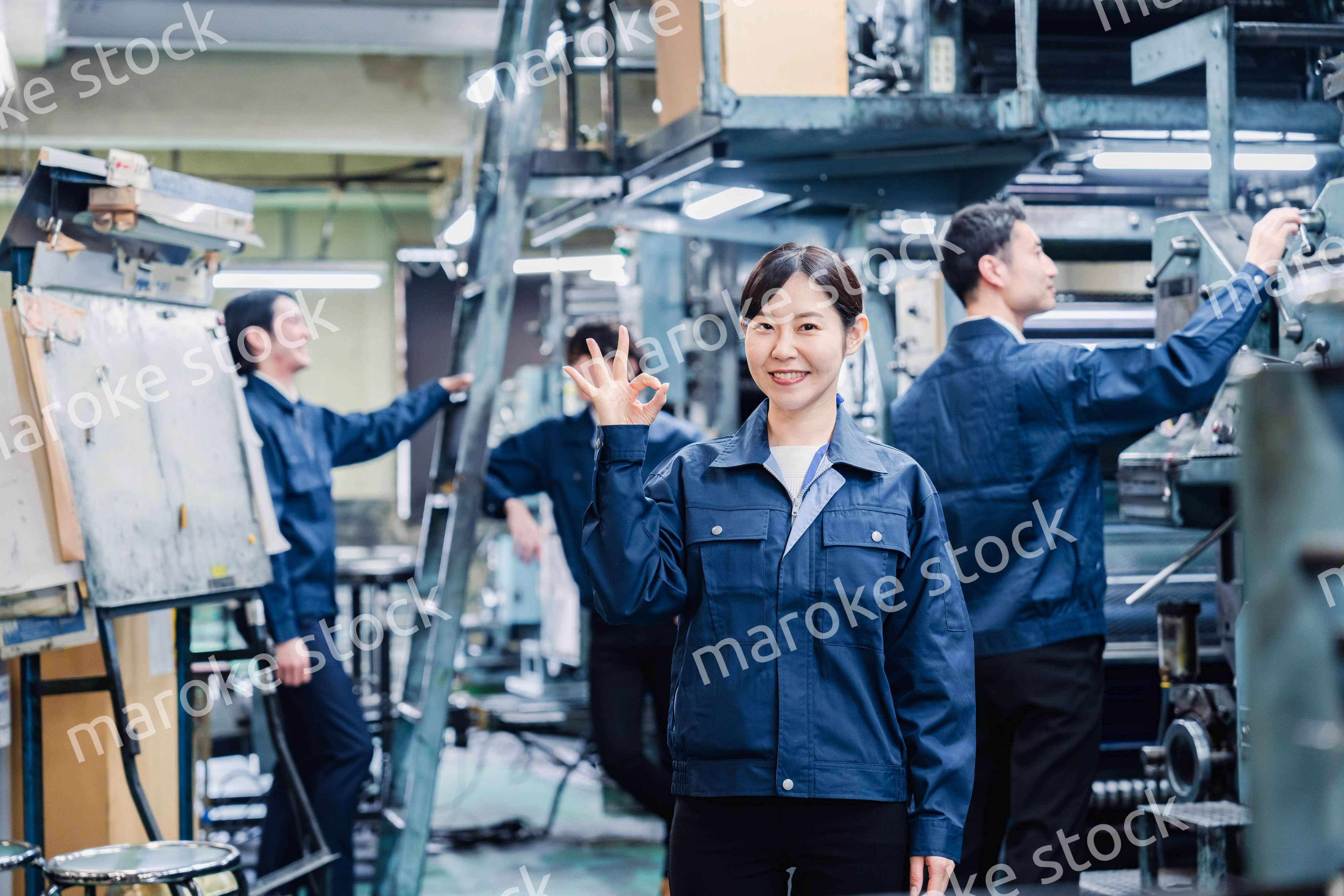OKサインを示す工場スタッフの女性