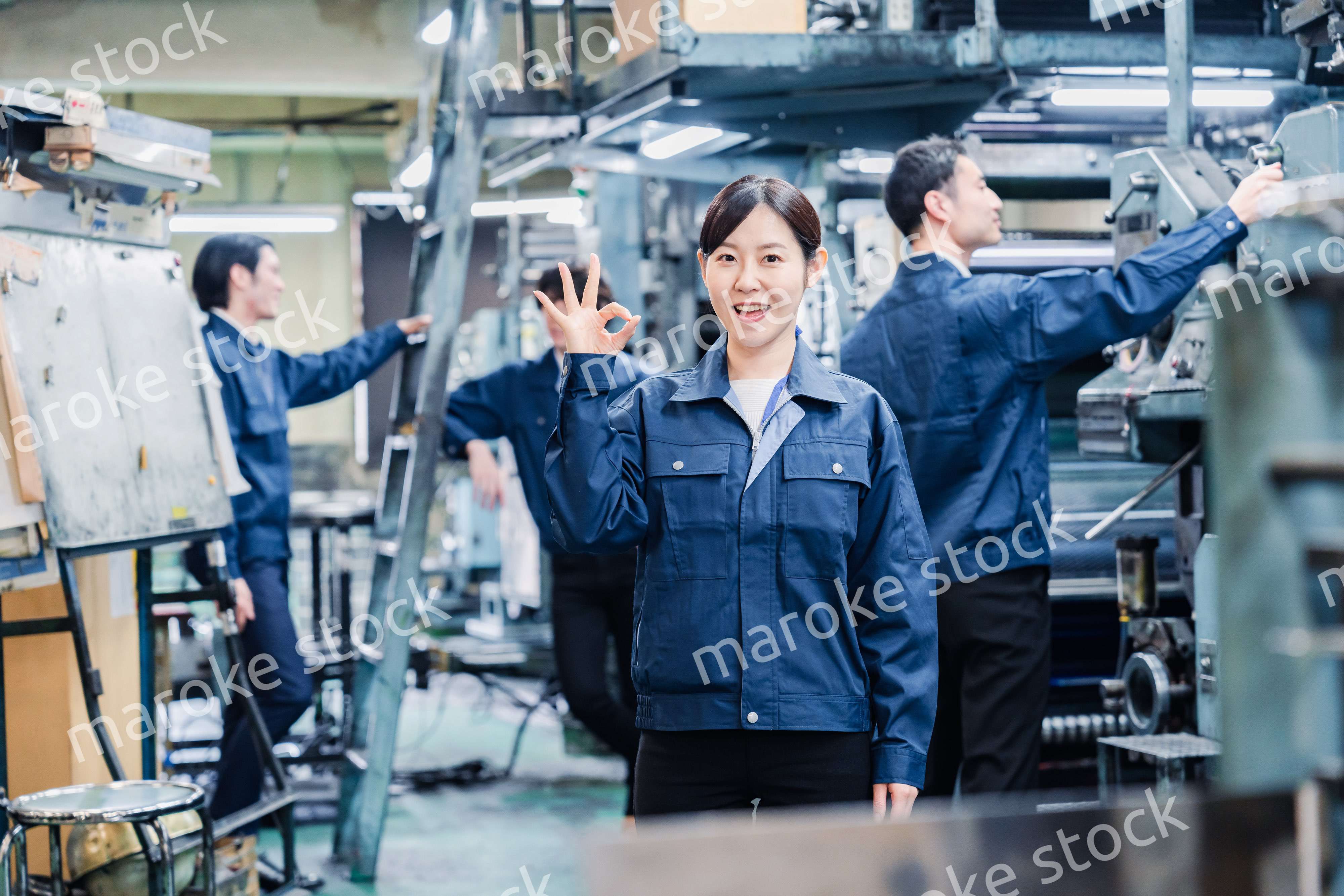 OKサインを示す工場スタッフの女性