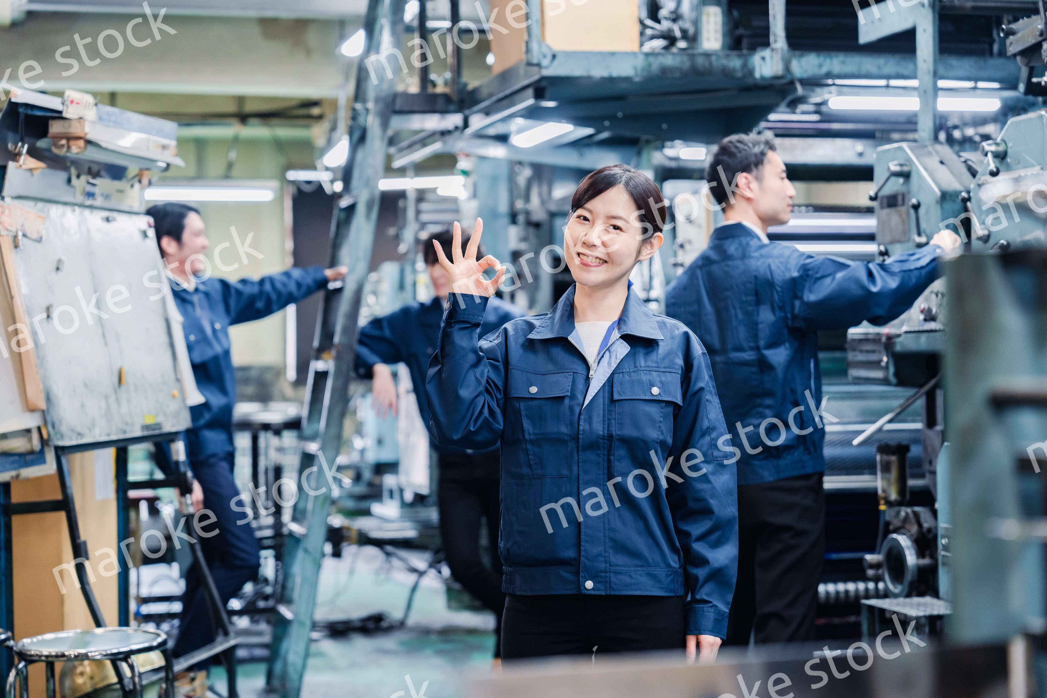 OKサインを示す工場スタッフの女性