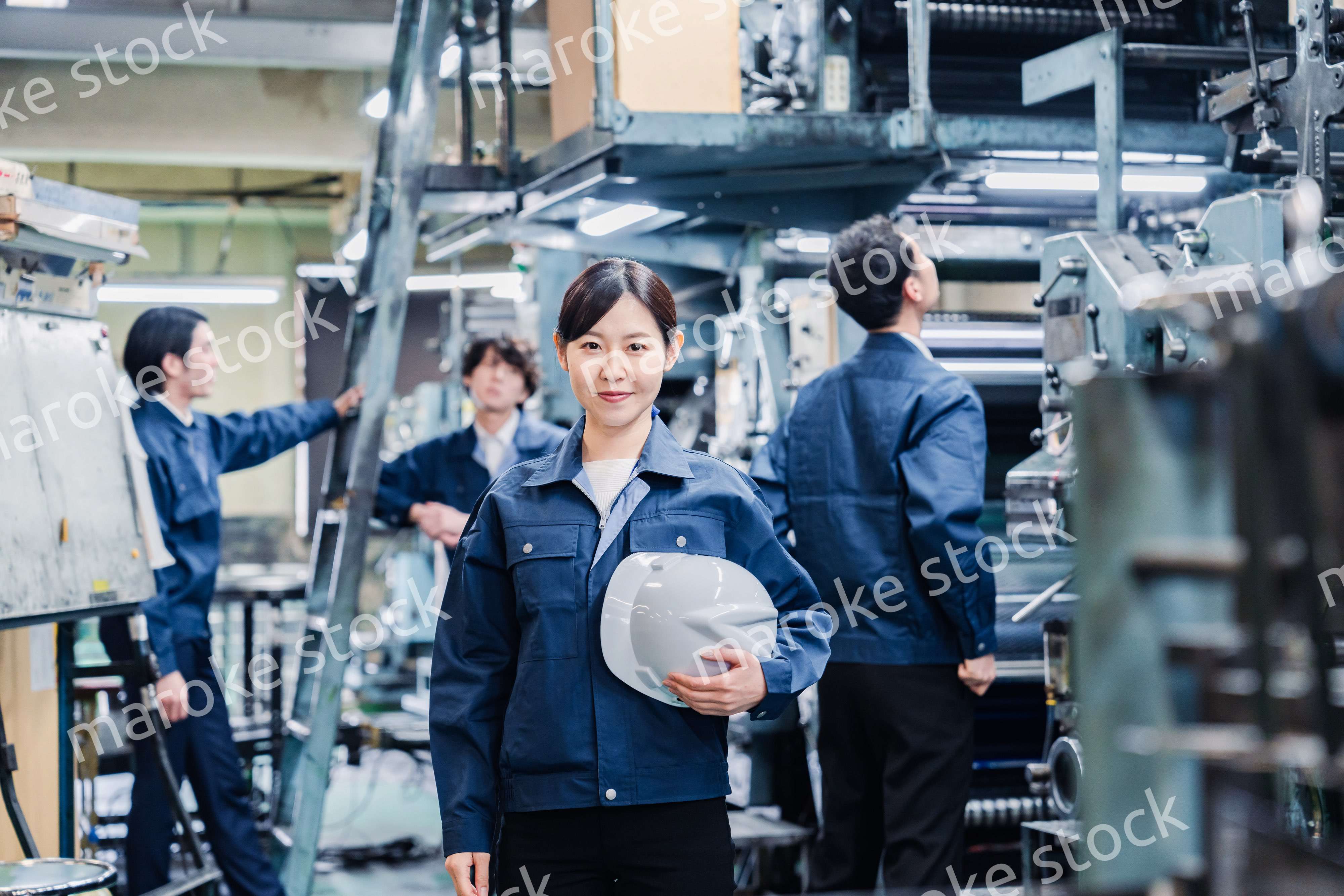 ヘルメットを持つ女性作業員