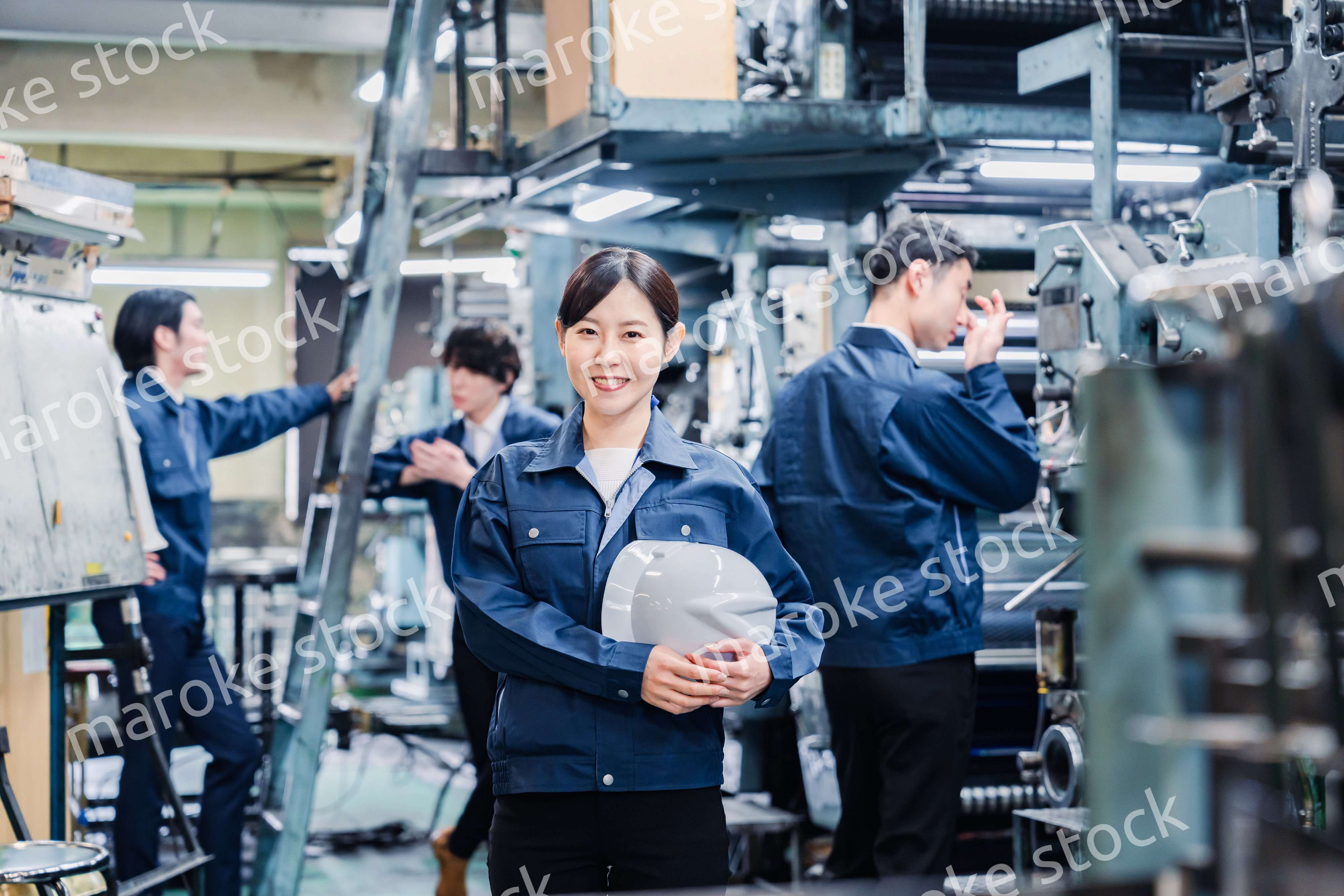 ヘルメットを持つ女性作業員