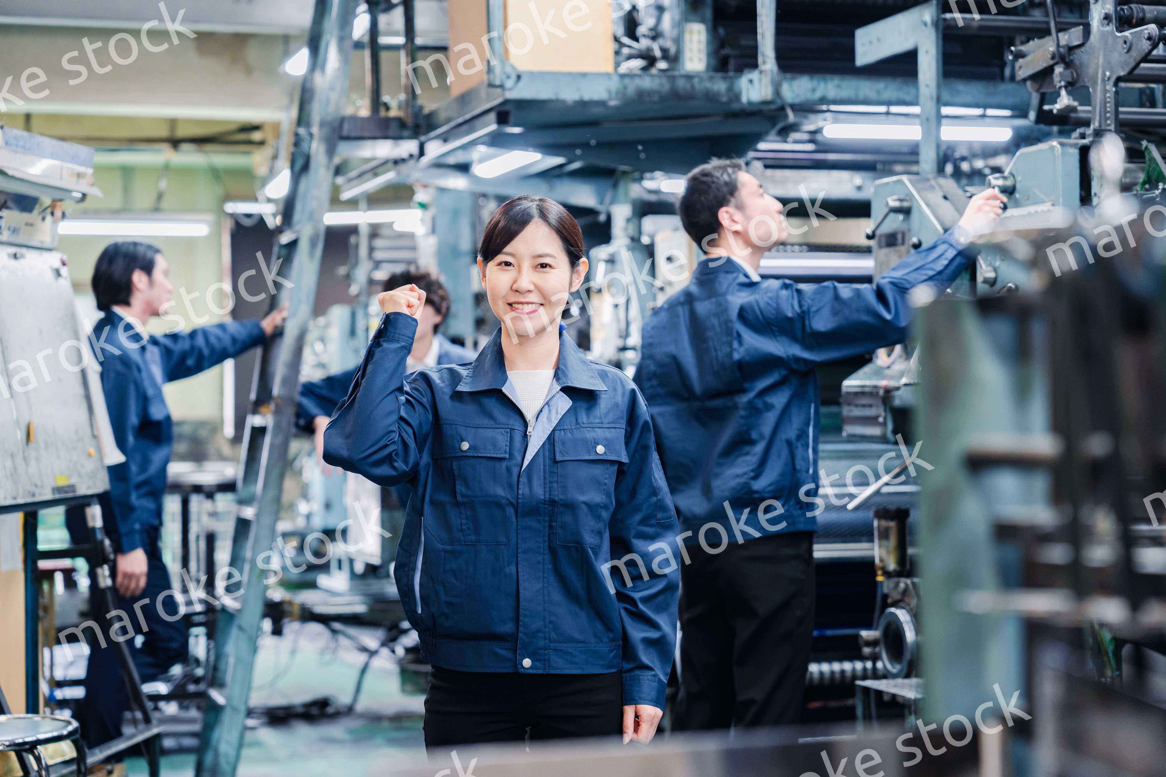 ガッツポーズをする工場労働者