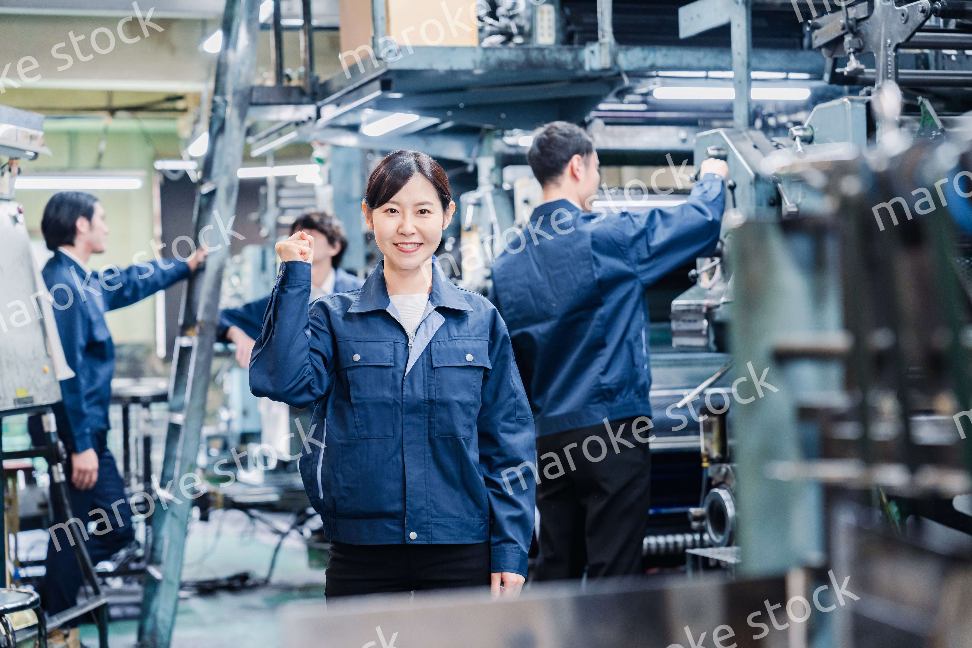 ガッツポーズをする工場労働者