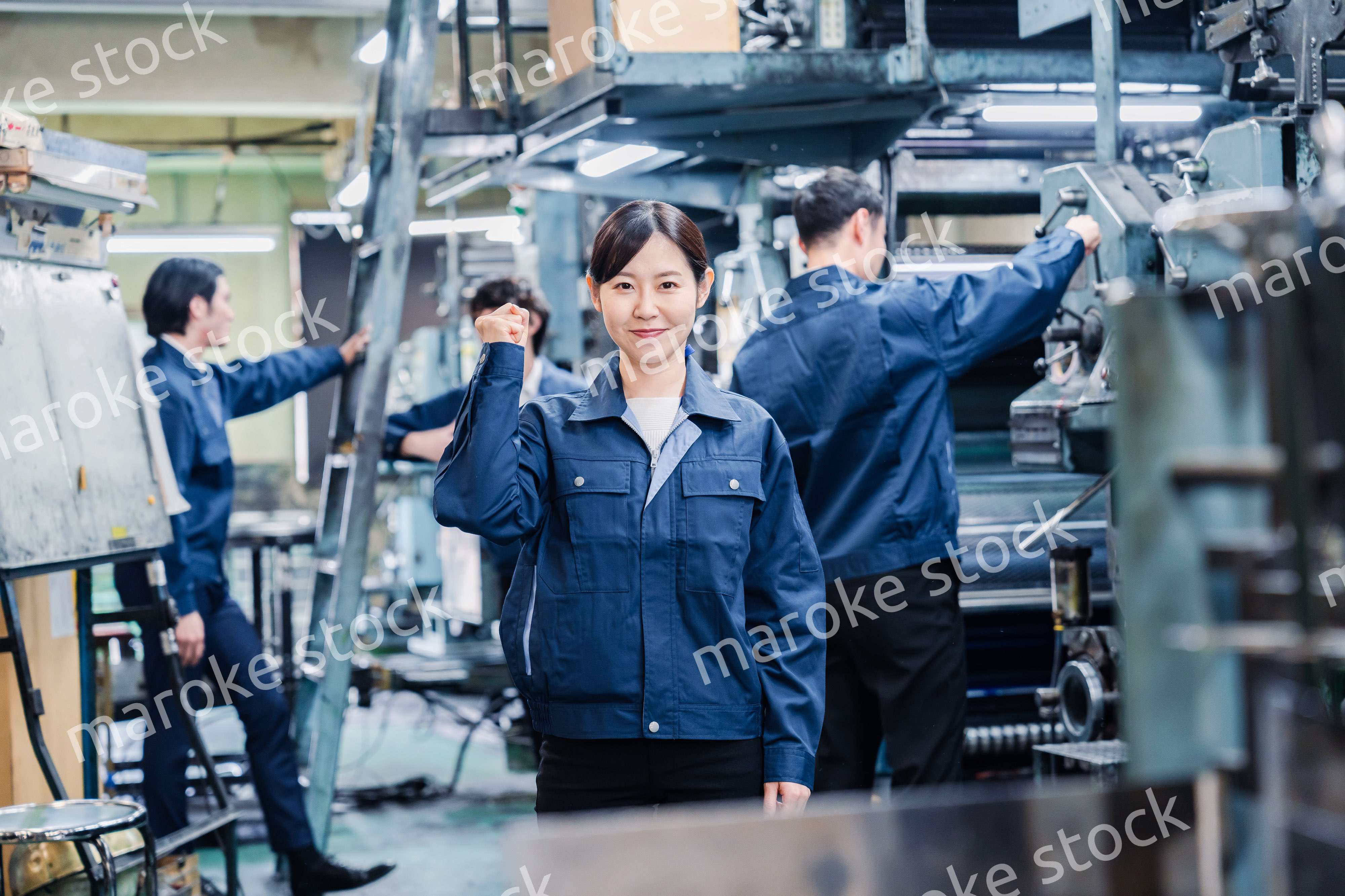 ガッツポーズをする工場労働者