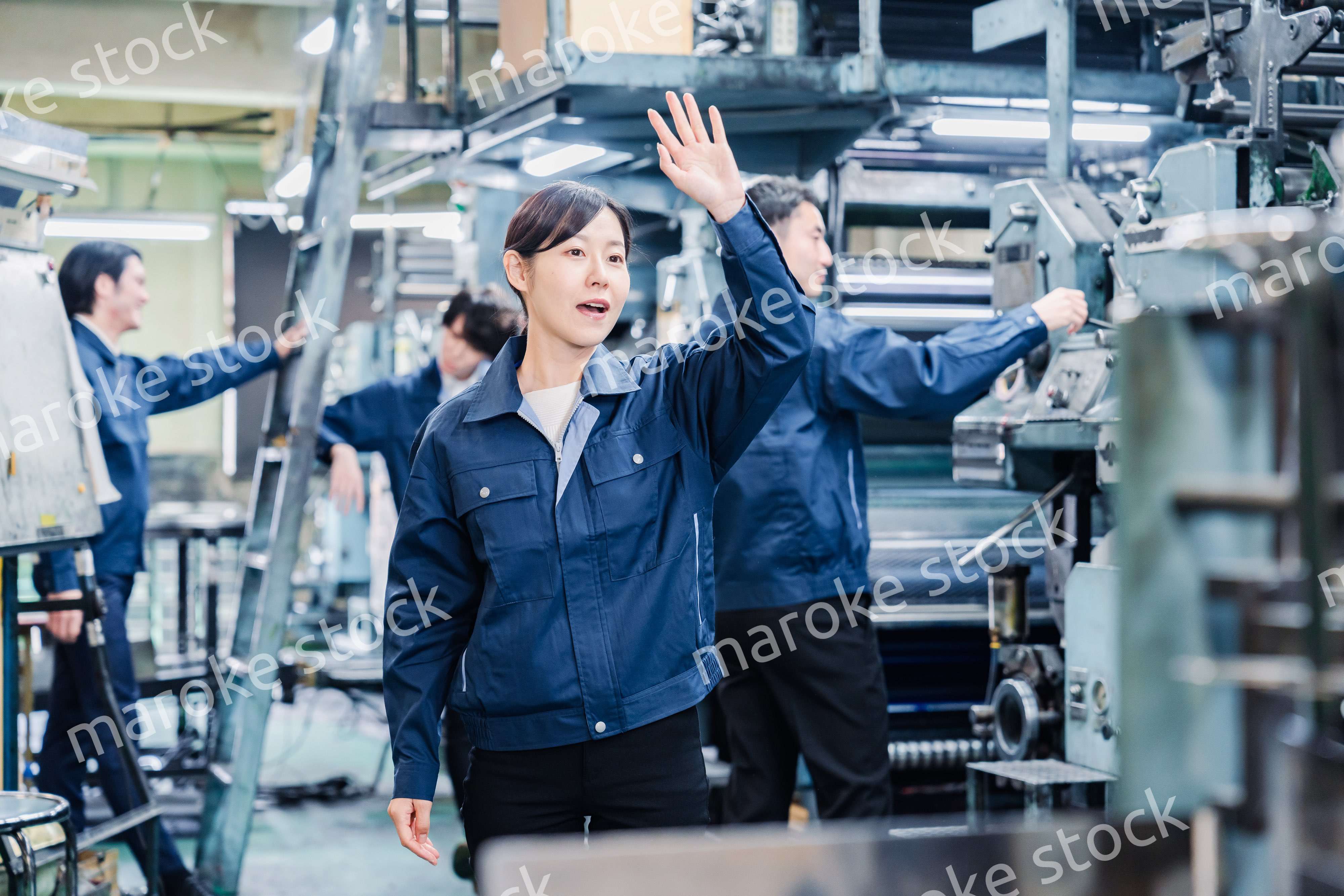 工場で手をふる女性の労働者