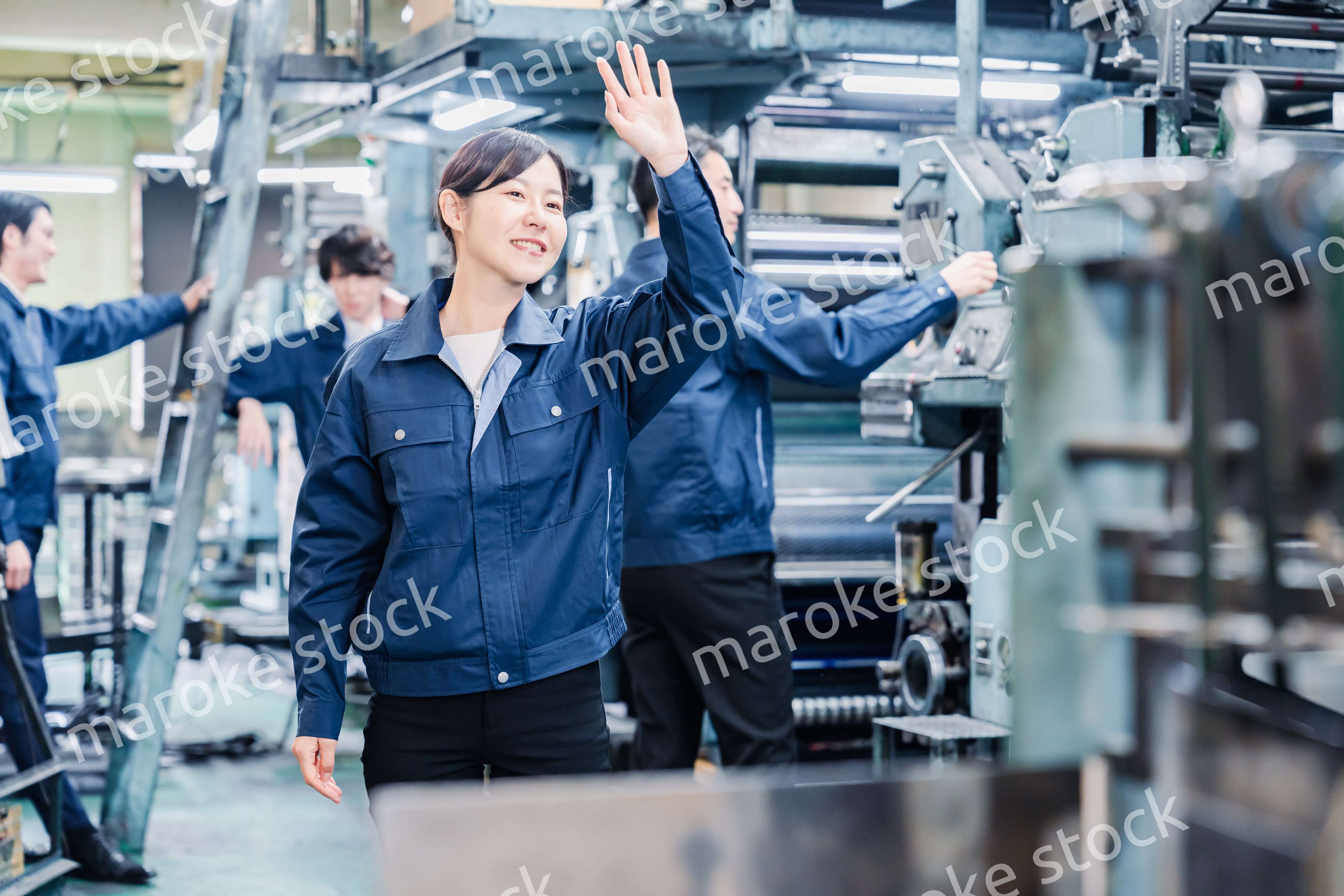 工場で手をふる女性の労働者