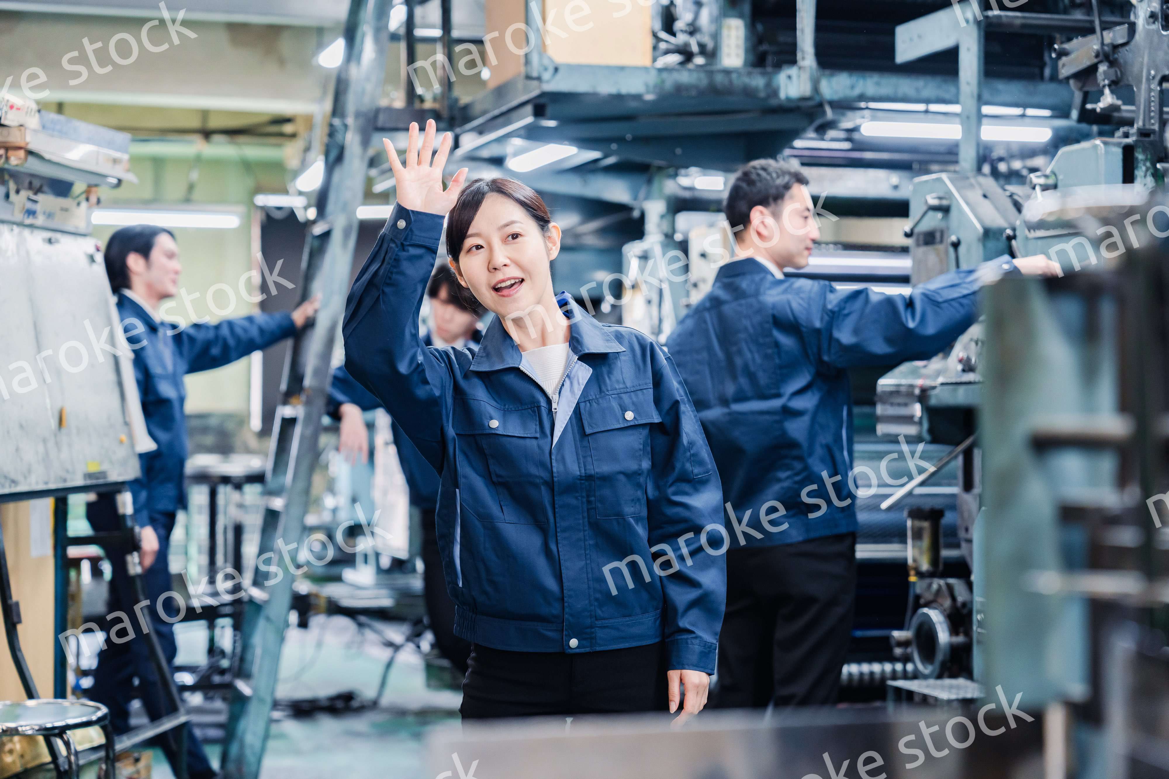工場で手をふる女性の労働者