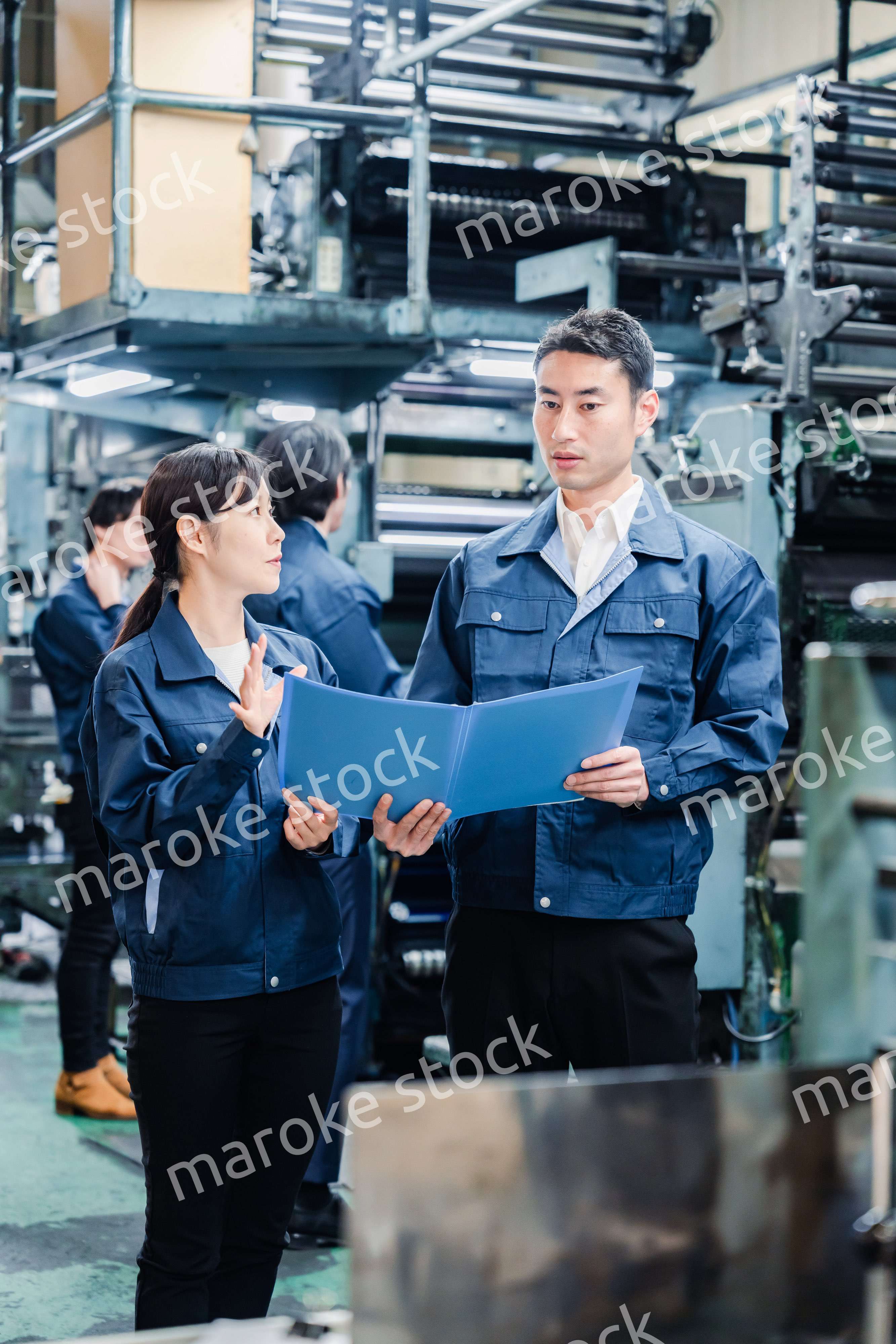 工場で生産計画を確認する労働者