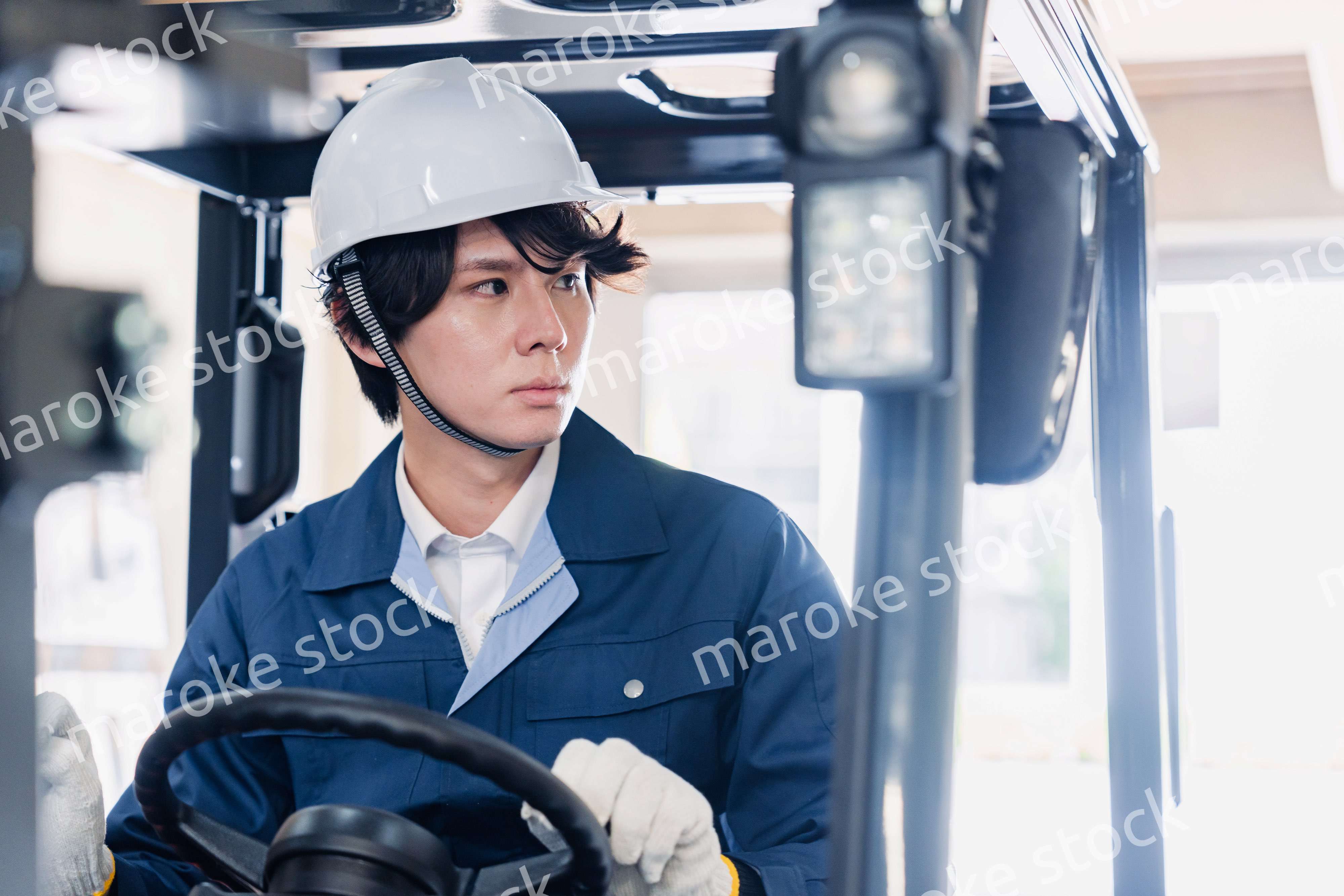 建設現場で重機に乗る作業員