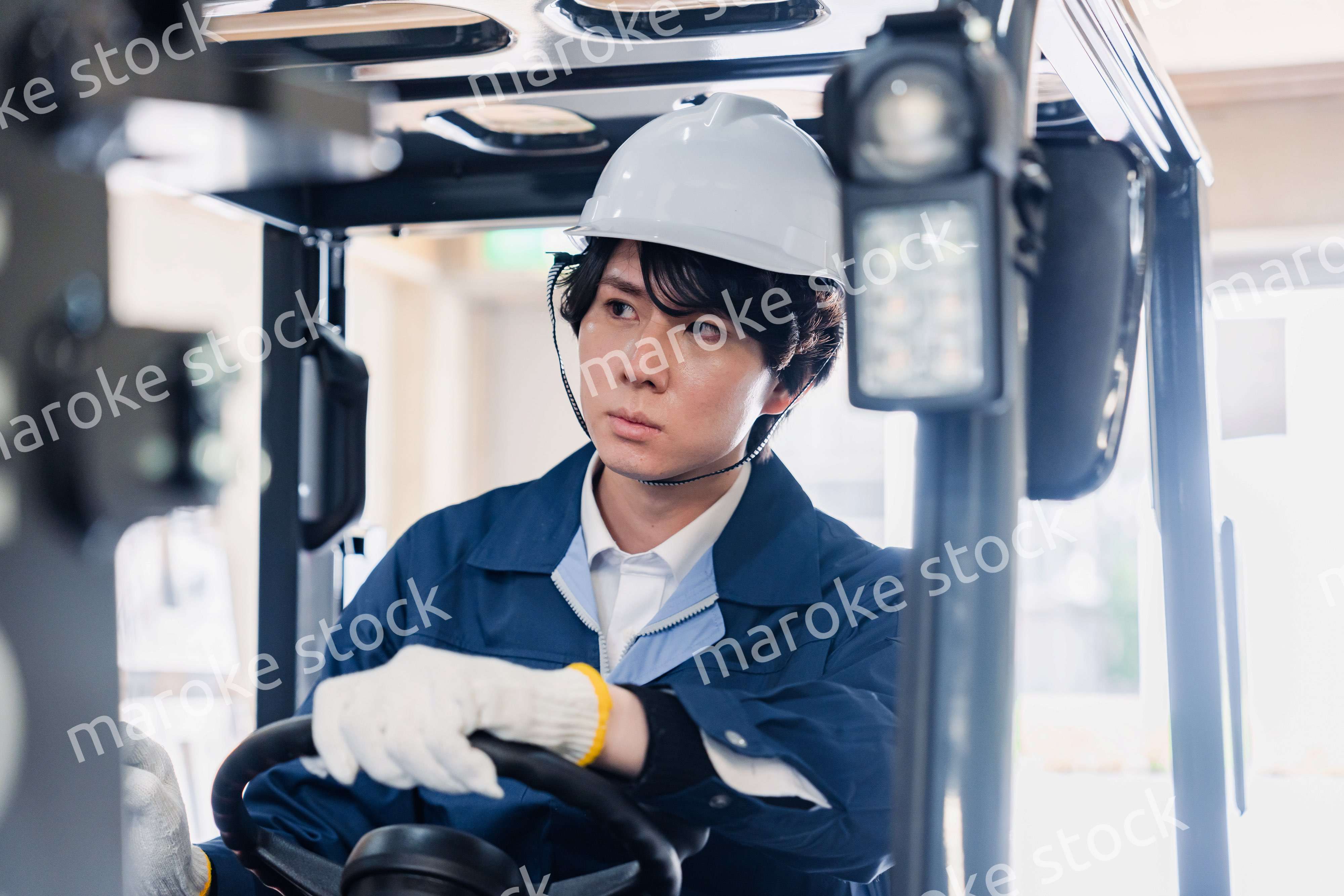 建設現場で重機に乗る作業員