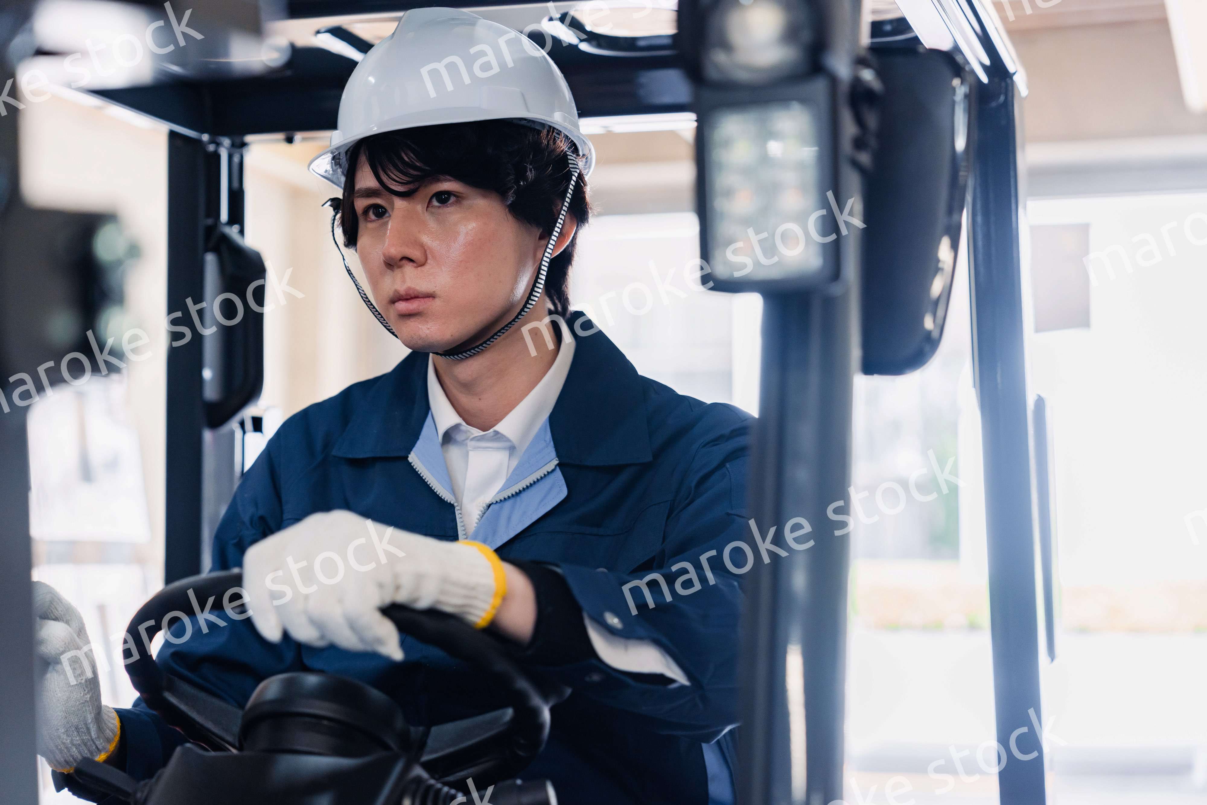 建設現場で重機に乗る作業員