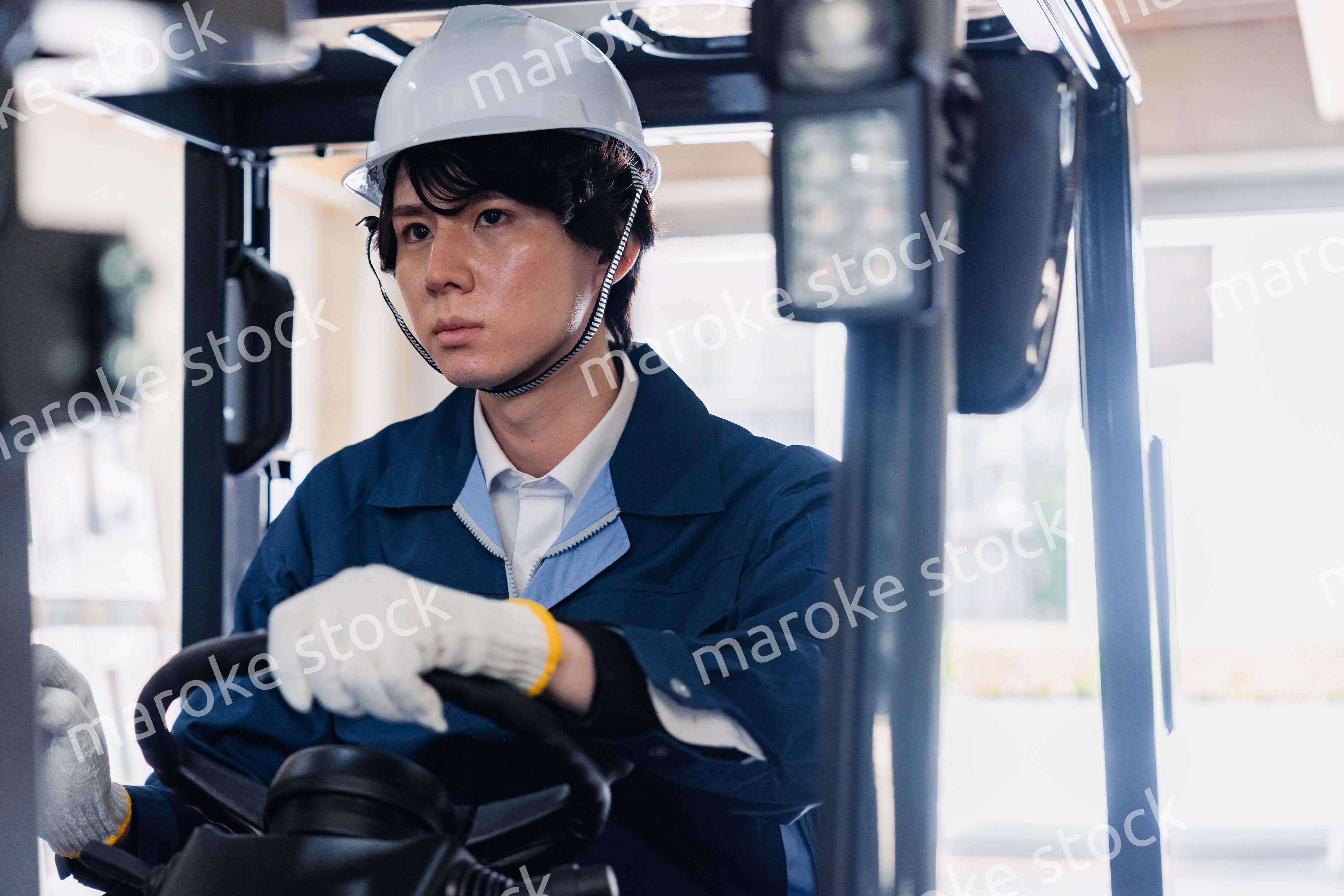 建設現場で重機に乗る作業員