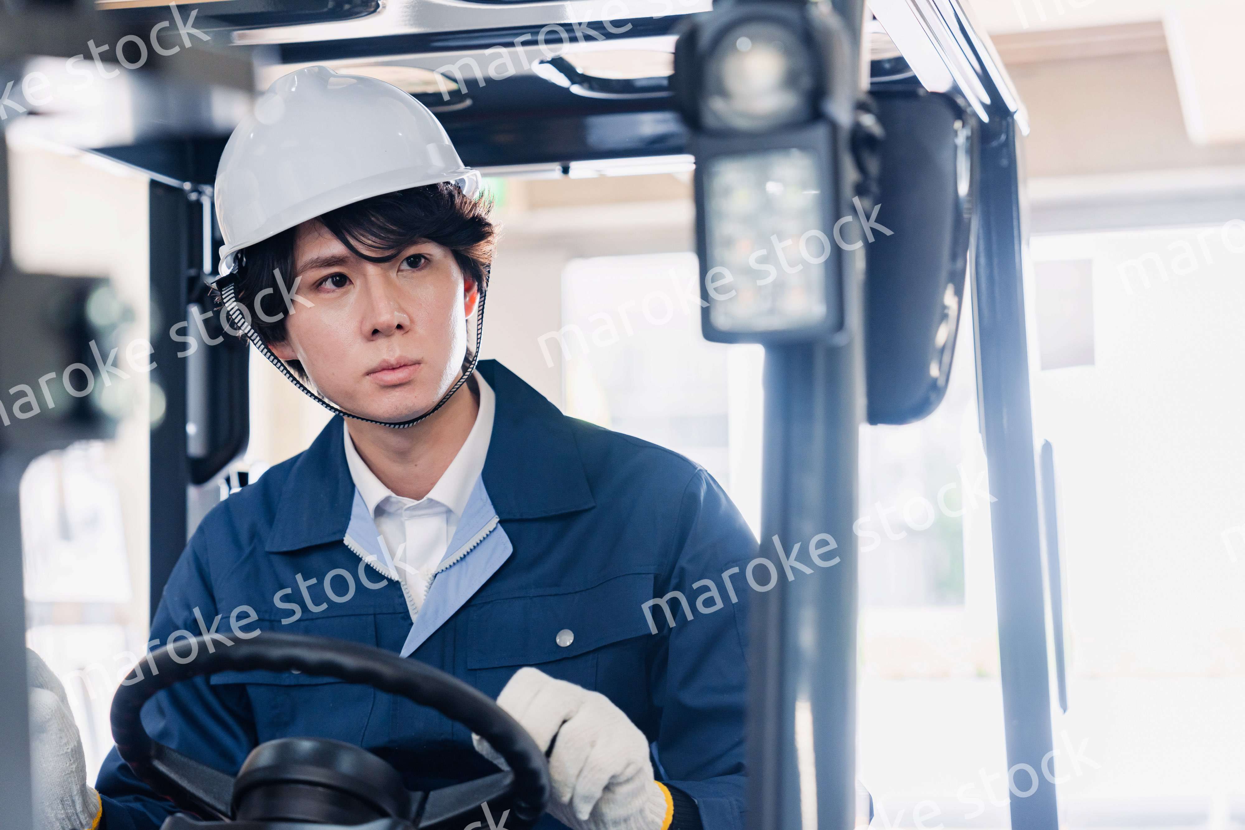 建設現場で重機に乗る作業員