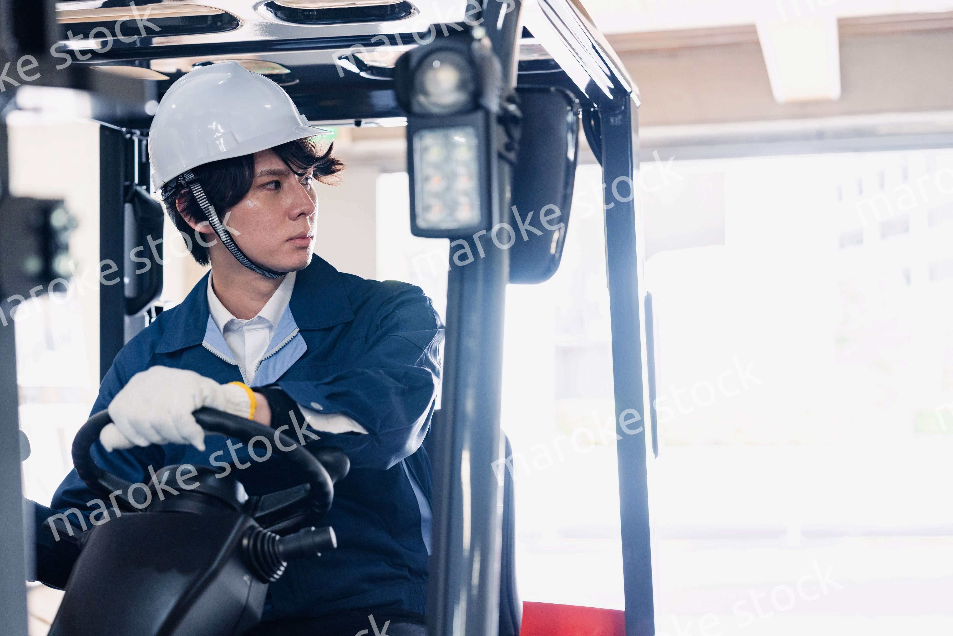 建設現場で重機に乗る作業員