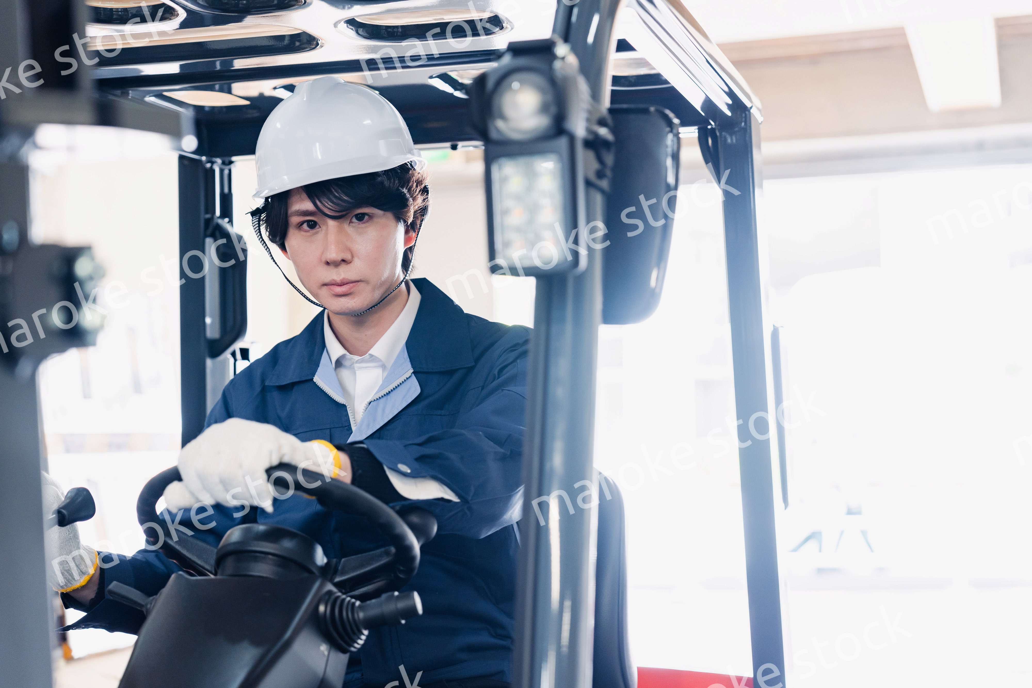 建設現場で重機に乗る作業員