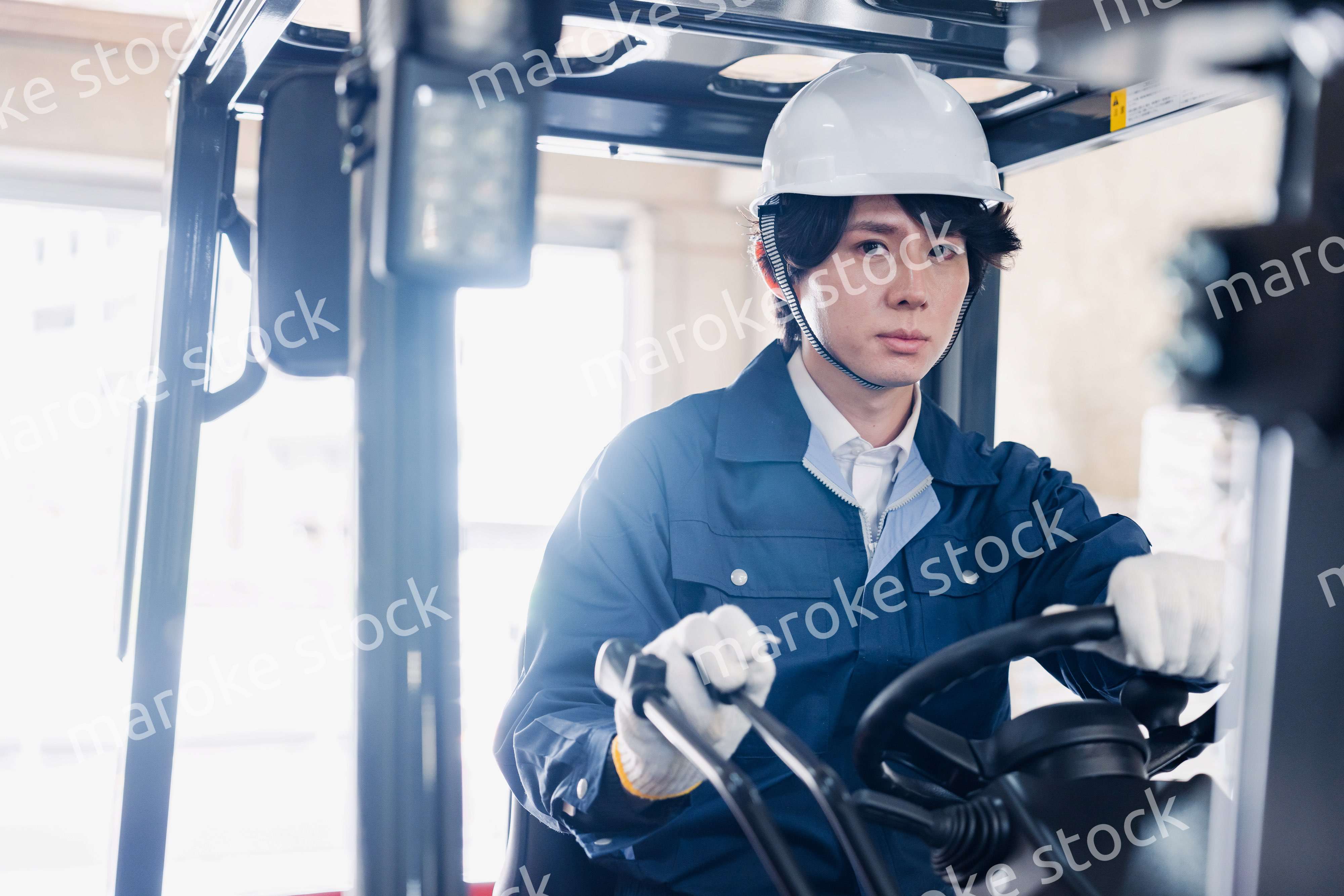 建設現場で重機に乗る作業員