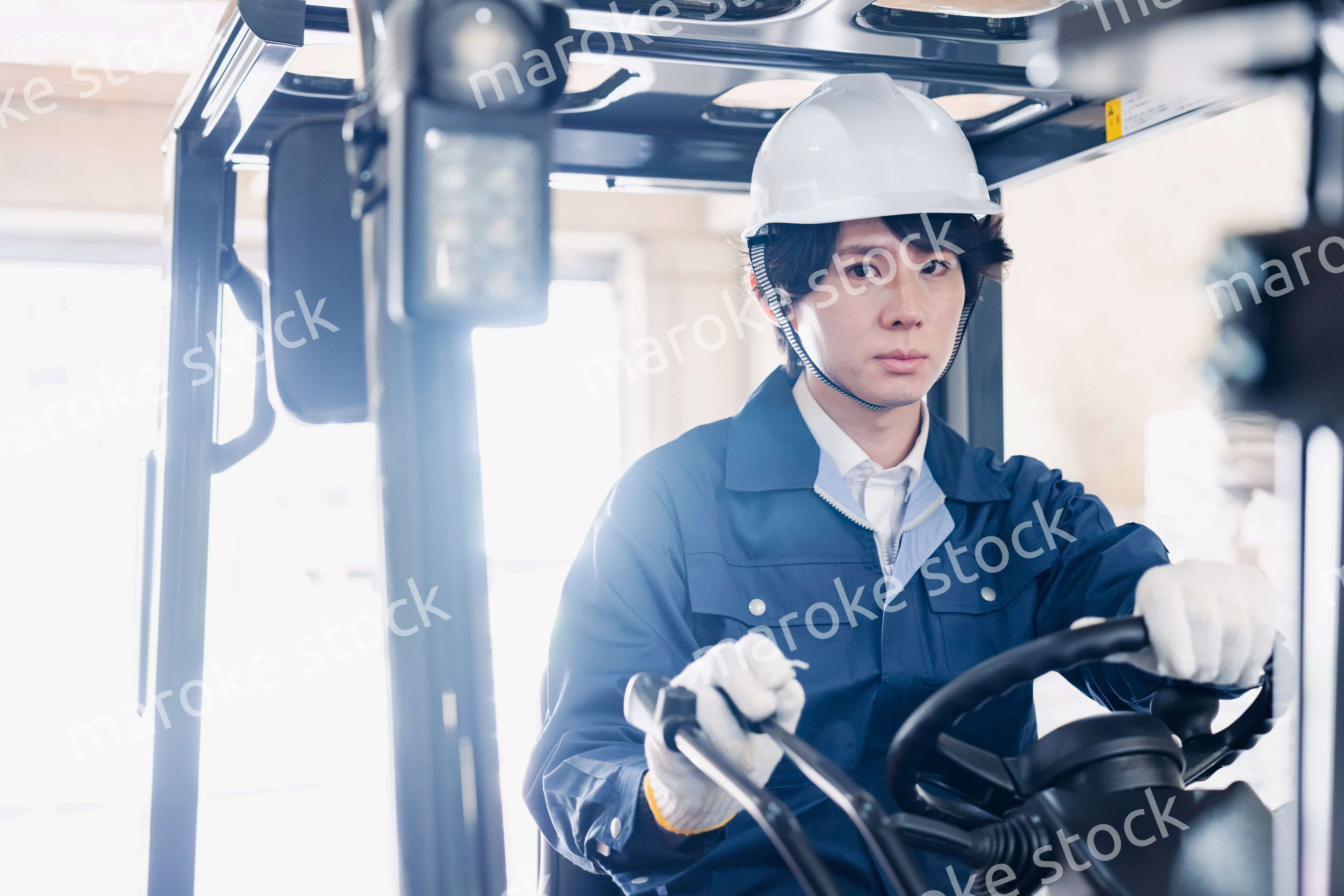 建設現場で重機に乗る作業員