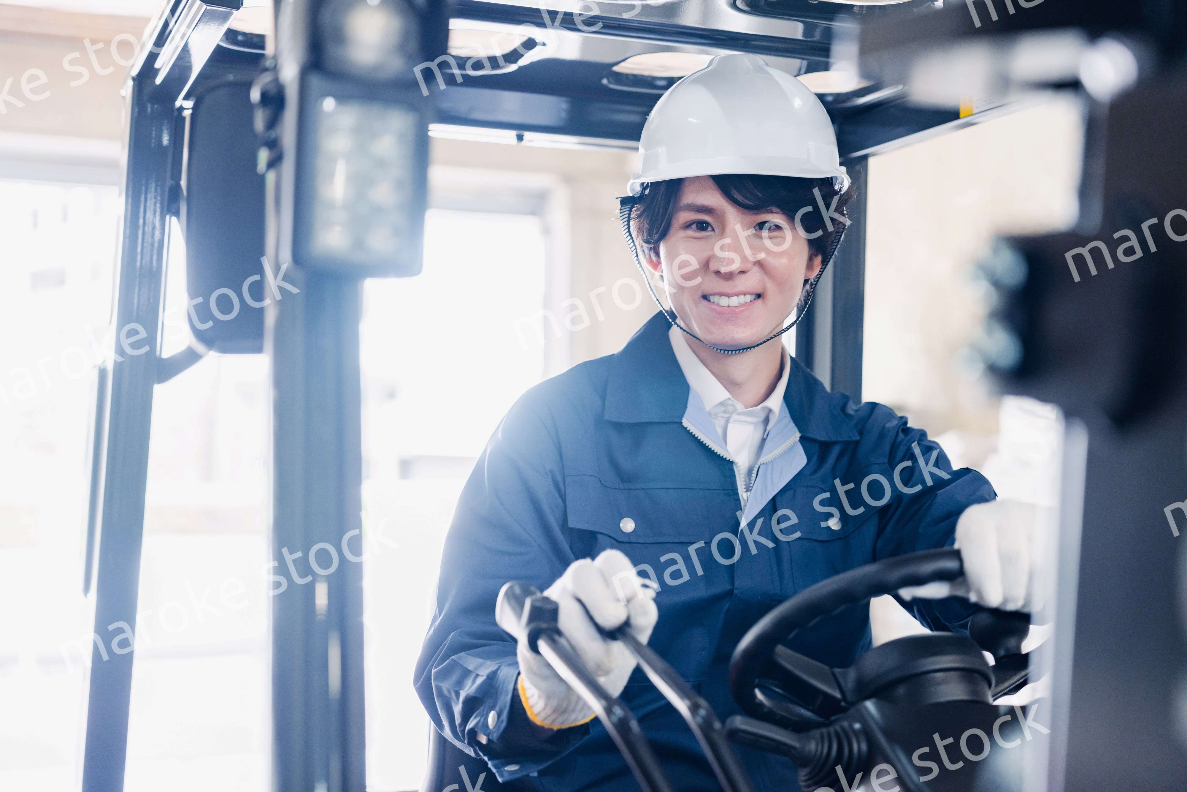 建設現場で重機に乗る作業員