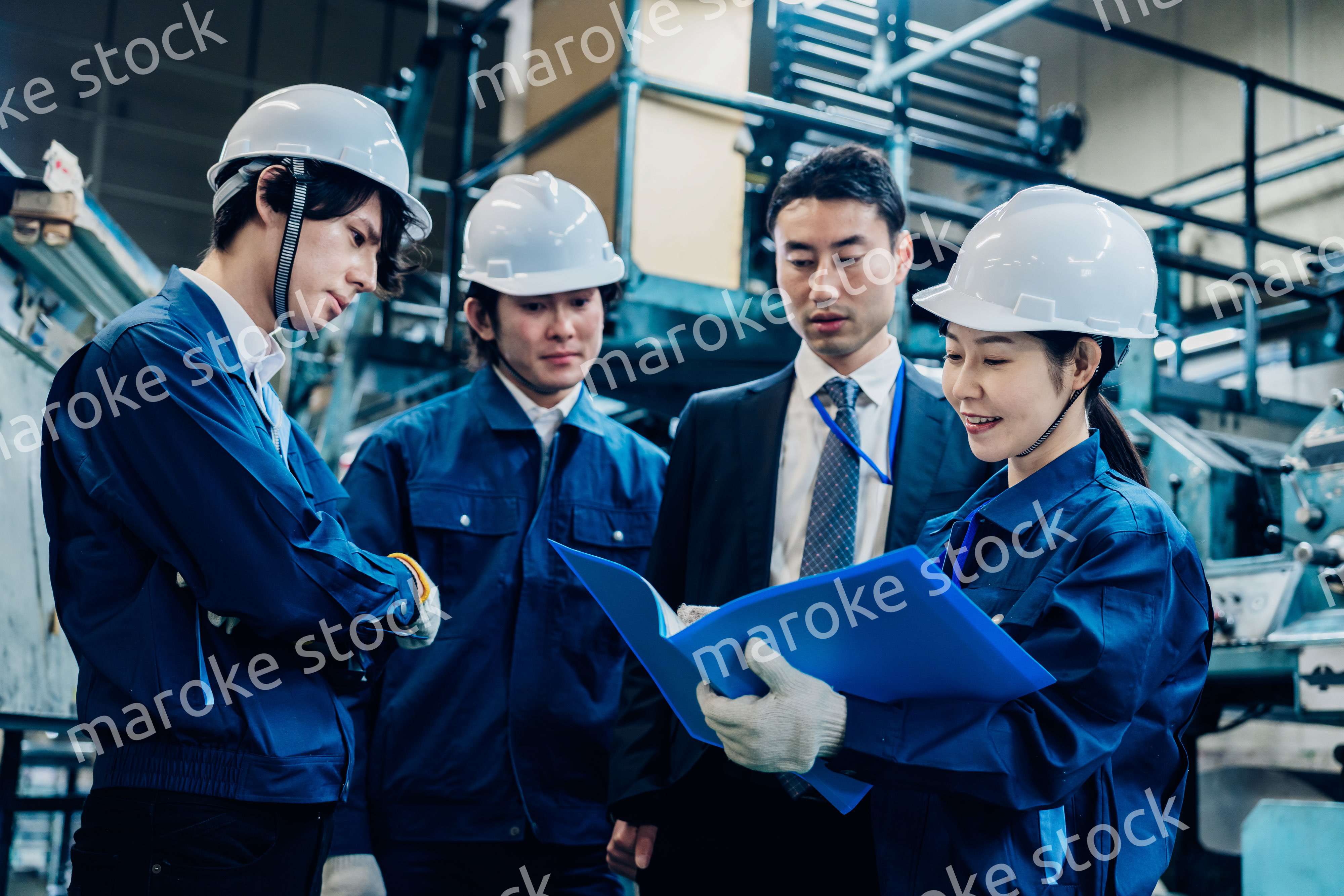 工場で資料を確認する労働者