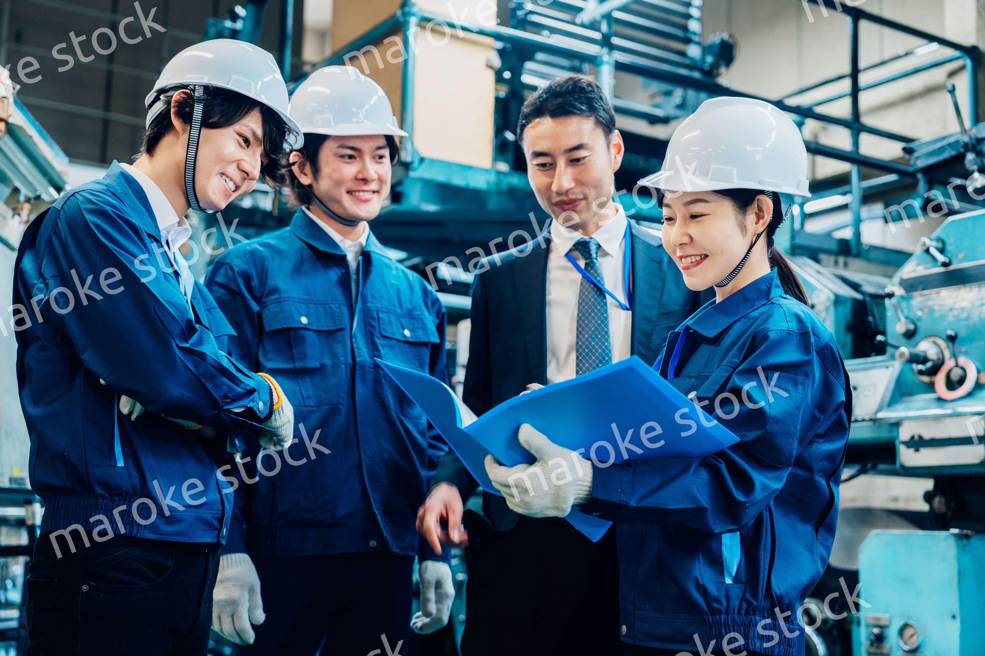 工場で資料を確認する労働者