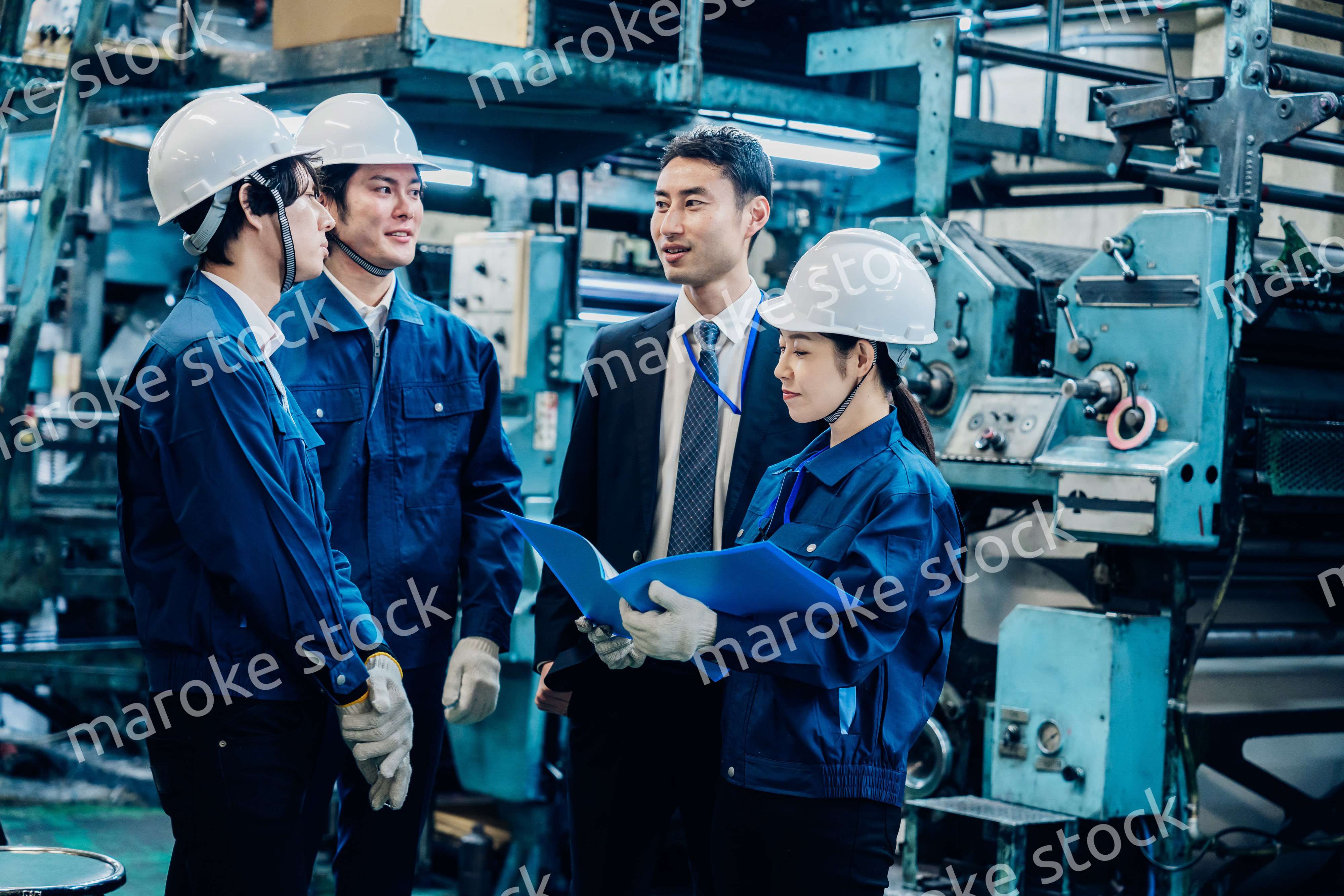 工場で資料を確認する労働者