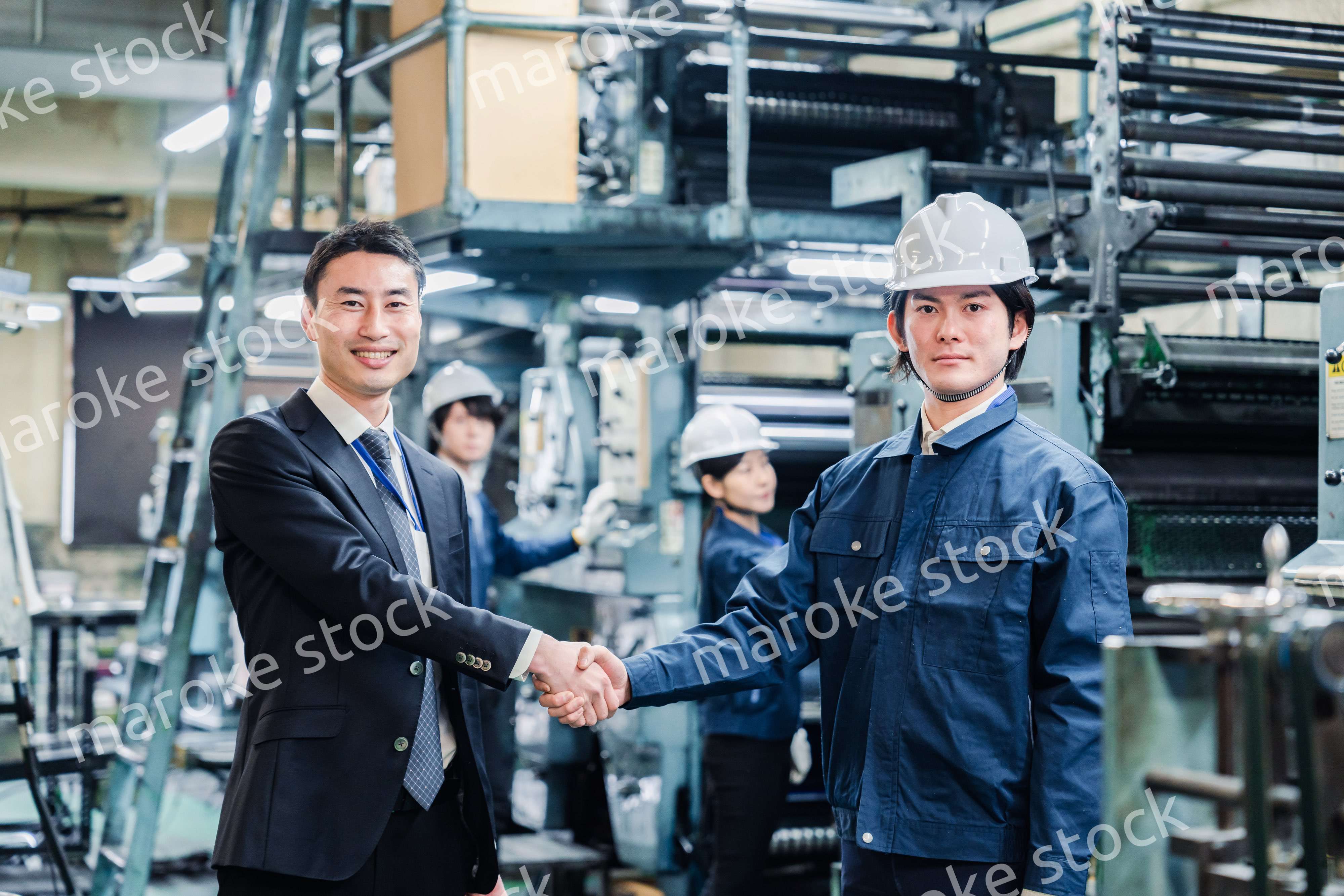 取引先と握手をする工場のスタッフ